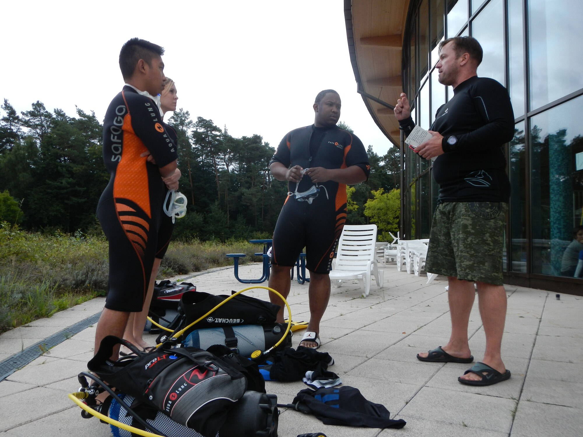 Easy Dive instructor Mike Johnson (center) instructs students on the basics of scuba diving, Sept. 11, 2013, Ramstein Air Base, Germany. During the new Scuba Diving Certification Course at Ramstein’s Aquatic Center students will learn the basic principles of scuba diving. (U.S. Air Force photo/Senior Airman Caitlin Guinazu)