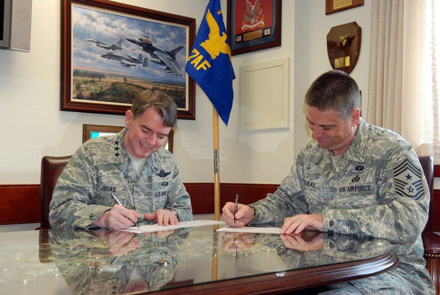 OSAN AIR BASE, Republic of Korea - Lt. Gen. Jan-Marc Jouas, Seventh Air Force commander, and Command Chief Master Sgt. Scott Delveau, Seventh Air Force command chief, fill out their Combined Federal Campaign paperwork in Jouas's office Sept. 18, 2013. The CFC allows members of the military and government employees to donate money to worthy causes and help those less fortunate than themselves. Last year Seventh Air Force raised more than $364,000 and plans to beat that amount this year.