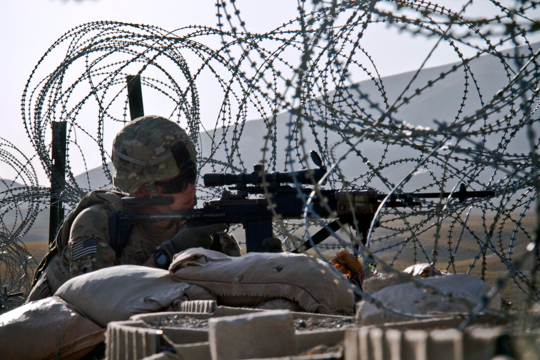 U.S. Army Spc. Charles R. Reiff uses the optic lens on his MK-14 Enhanced Battle Rifle to scan his sector while providing security on Combat Outpost Kaligu in Afghanistan, Sept. 11, 2013. Reiff, an indirect fire infantryman, is assigned to the 101st Airborne Division's Company D, 1st Battalion, 506th Infantry Regiment, 4th Brigade Combat Team.
