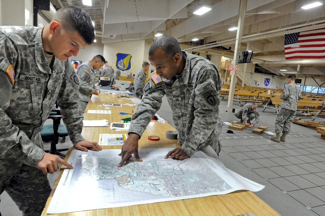 Army Spc. Michael Maestas, left, and Army Sgt. Cameron Marsh look over a training area map before a combat training parachute insertion on Joint Base Elmendorf-Richardson, Alaska, Sept. 9, 2013. Maestas and Marsh are assigned to the 25th Infantry Division's Company B, 1st Battalion, 501st Infantry Regiment, 4th Infantry Brigade Combat Team Airborne, Alaska.