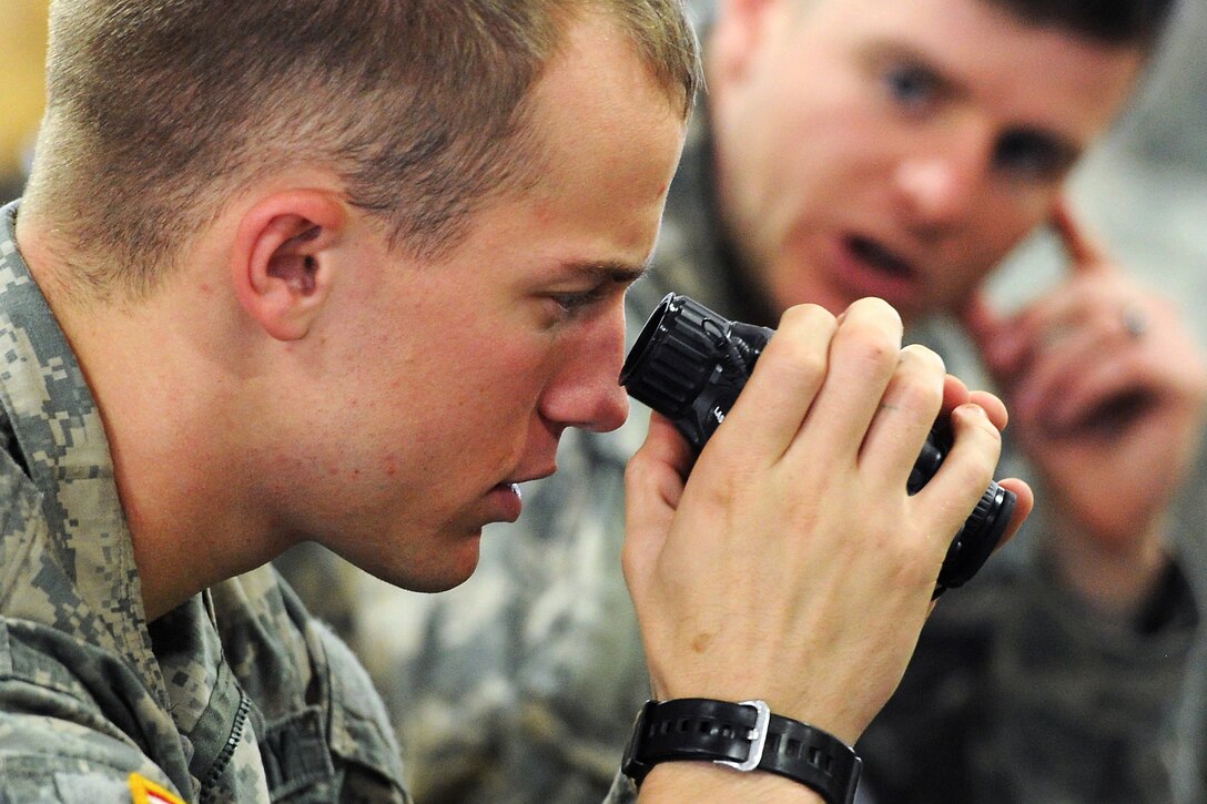 Army Spc. Nicholas Kuefler tests mini thermal monocular, night vision optic lenses before a combat training parachute insertion on Joint Base Elmendorf-Richardson, Alaska, Sept. 9, 2013. Kuefler is assigned to the 25th Infantry Division's Company A, 1st Battalion, 501st Infantry Regiment, 4th Infantry Brigade Combat Team Airborne, Alaska.