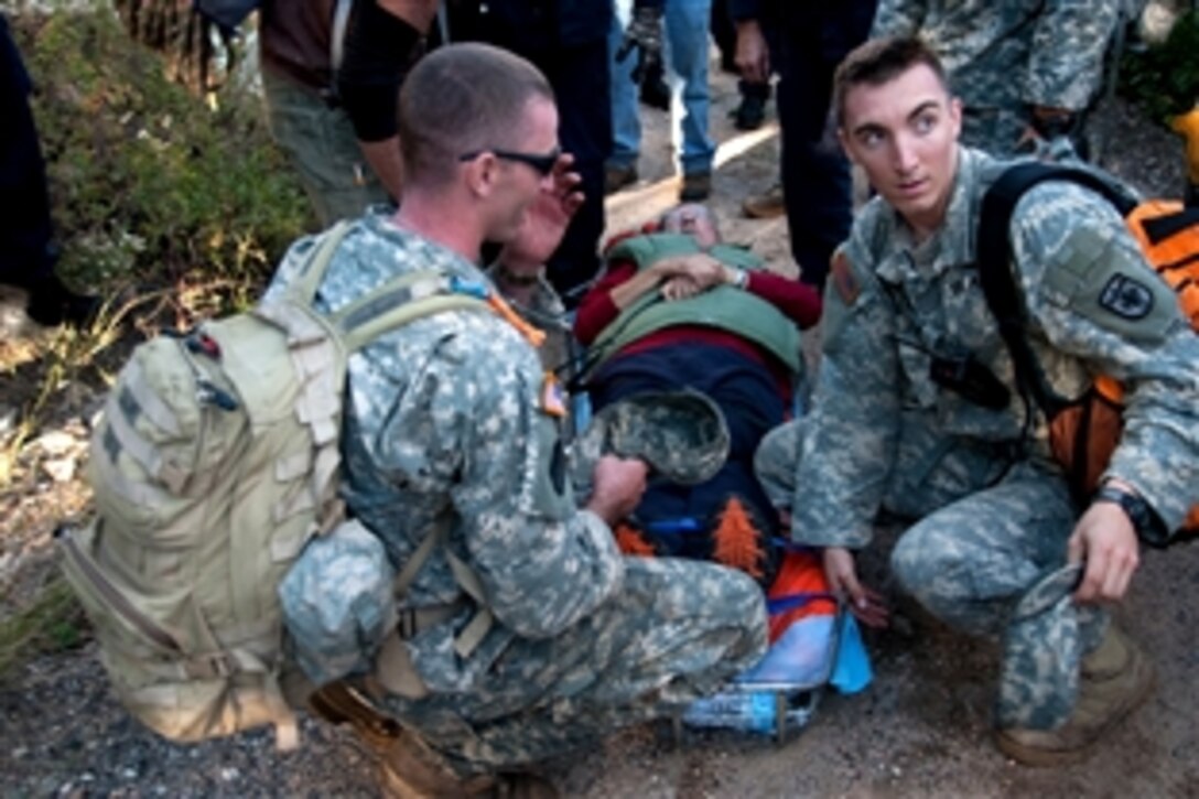 Soldiers and civilian rescue personnel use a rescue basket to carry an elderly man on oxygen to a UH-60 Black Hawk helicopter in Glen Haven, Colo., Sept. 16, 2013, in support of flood relief operations in Larimer County. 