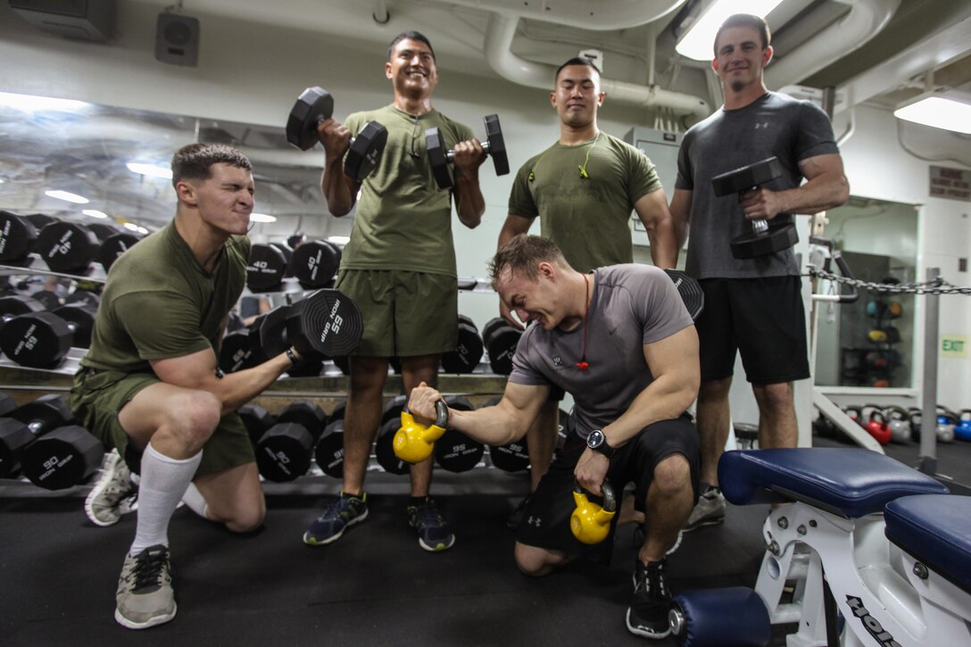 USS BONHOMME RICHARD, At Sea – Marines with the 31st Marine Expeditionary Unit pause their workout to pose for a “meathead” group photo here, Sept. 13.   Physical training gives Marines more than just bulging biceps, it serves as an outlet for anger, keeps an anxious mind occupied and builds unit camaraderie through shared pain and success. (Marine Corps photo by Sgt. Paul Robbins)