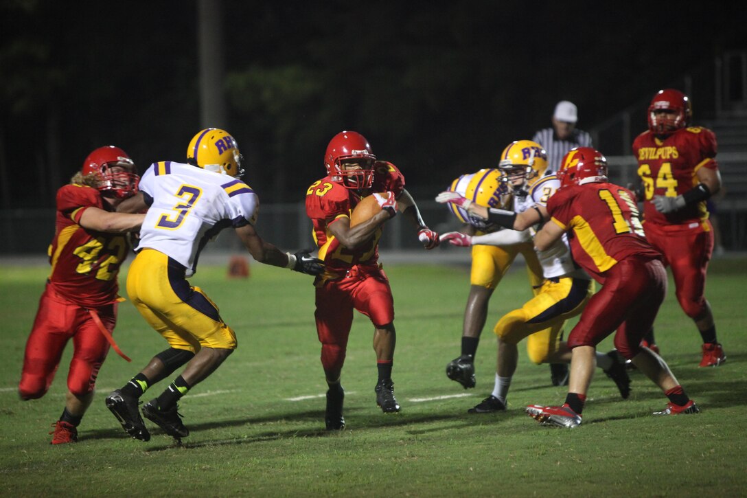 Jamaz Richardson, a Lejeune Devil Pups running back, tries to maneuver around two defenders during their game versus Rosewood High School aboard Marine Corps Base Camp Lejeune, Sept. 13. The Devil Pups beat Rosewood 42-12. 