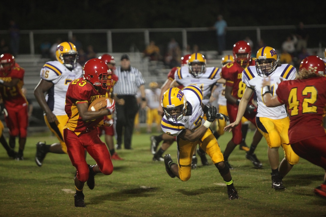 Jamaz Richardson, a Lejeune Devil Pups running back, tries to evade a defender during their game versus Rosewood High School aboard Marine Corps Base Camp Lejeune, Sept, 13. Richardson scored four touchdowns during the game. 