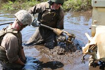 Marines with Ordnance Maintenance Company, 2nd Maintenance Battalion, 2nd Marine Logistics Group attach a cable to a Mine-Resistant Ambush Protected vehicle during a regimental field exercise aboard Camp Lejeune, N.C., Sept. 9, 2013. The operation gave service members training experience in vehicle recovery, convoys, foot patrols and massive casualty response. (U.S. Marine Corps photo by Lance Cpl. Shawn Valosin)