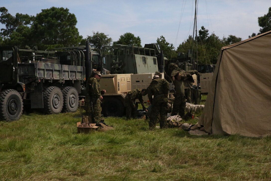 Marines and sailors put on protective clothing during a simulated chemical threat aboard Camp Lejeune, N.C. Sept. 11, 2013. This was just one of many drills performed during a field exercise by Combat Logistics Regiment 25. (U.S. Marine Corps photo by Lance Cpl. Shawn Valosin)