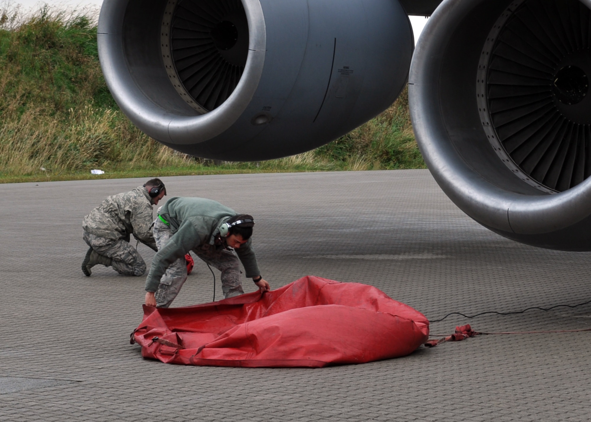 2nd Lt. Christopher Hickman, left, and Staff Sgt. Curtis McKee, 100th Air Refueling Wing, remove engine covers on a KC-135R Stratotanker prior to its disembarkment Sept. 16, 2013, for the Arctic Challenge exercise “play zones” over northern Norway. The 100th ARW provided all the aerial refueling for the exercise.