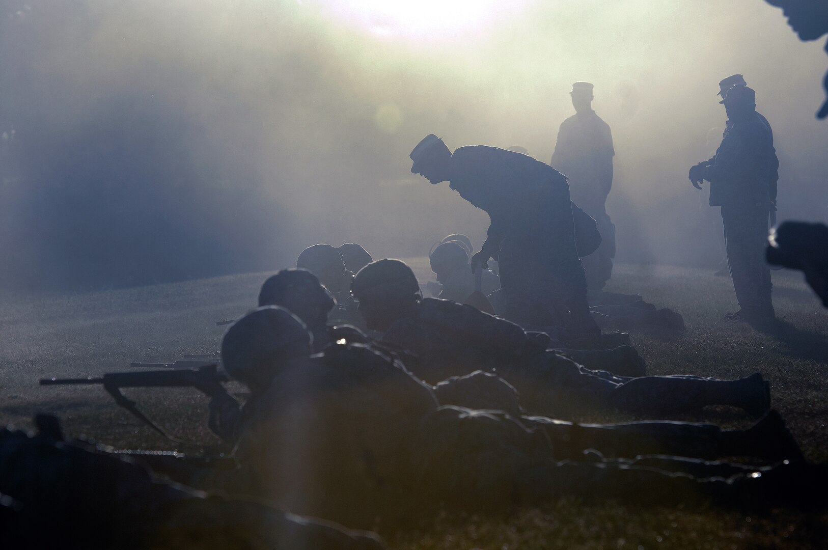 A range safety looks on as competitors engage targets with an M16 rifle during the Winston P. Wilson Markmanship Competition at Camp Joseph T. Robinson, Ark., Sept. 4, 2013.