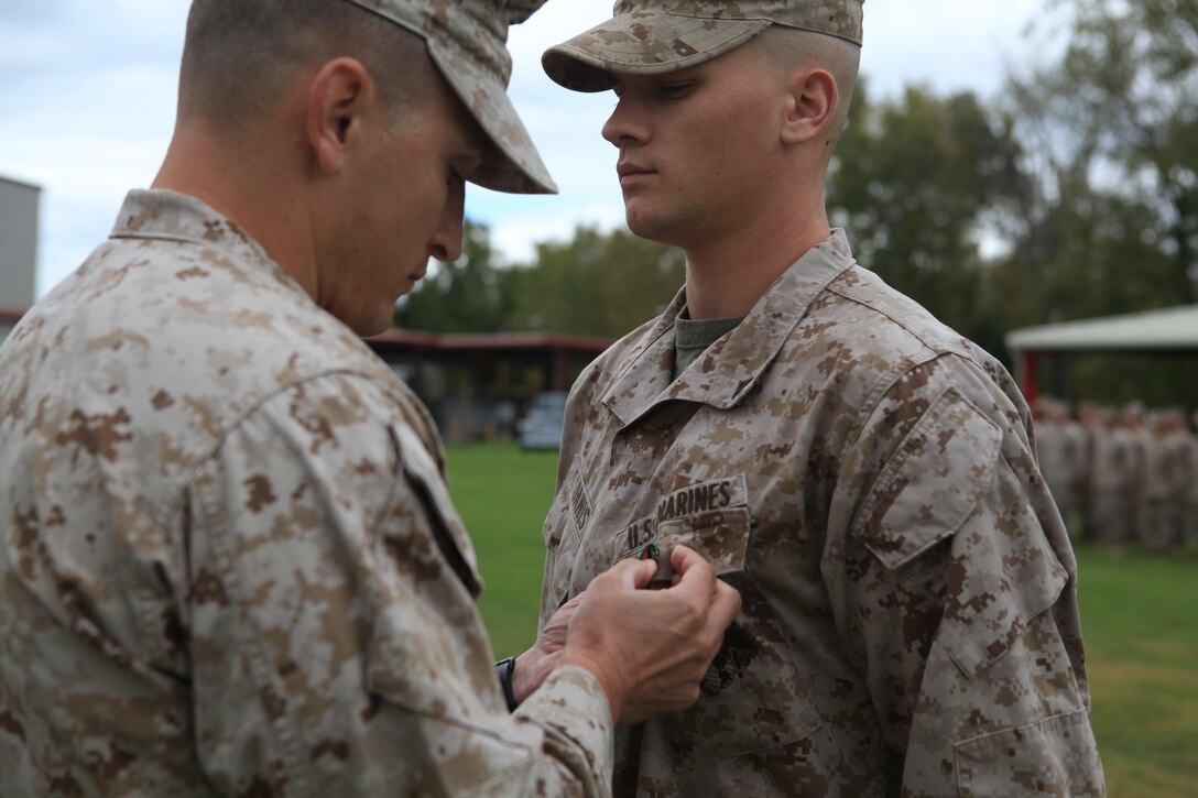 SYRACUSE, N.Y. -- Lance Cpl. Taylor Janis, a light-armored vehicle crewman with Company E, 4th Light-Armored Reconnaissance Battalion here, is pinned by his company commander at an awards ceremony, Sept. 14, 2013. Janis was awarded a Navy and Marine Corps Achievement Medal for saving an 8-year-old boy from a crashed car in March. (U.S. Marine Corps photo by Lance Cpl. Tiffany Edwards)
