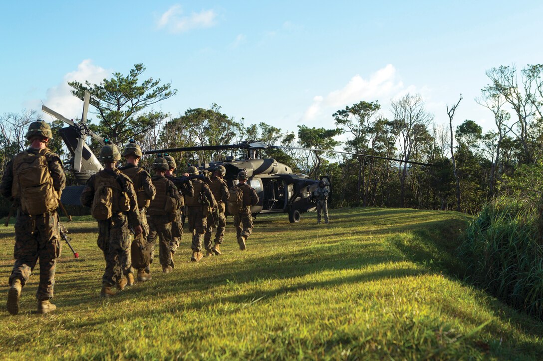 Marines make their way to a U.S. Army UH-60 Black Hawk helicopter Sept. 12 at Camp Schwab as part of the Exercise Lejeune II joint aerial assault training. The purpose of the training was to familiarize the Marines with helicopter-borne and landing zone security operations before conducting nighttime raids on an objective. The Marines are with 3rd Bn., 3rd Marines, currently assigned to 4th Marines, 3rd Marine Division, III MEF, under the UDP.