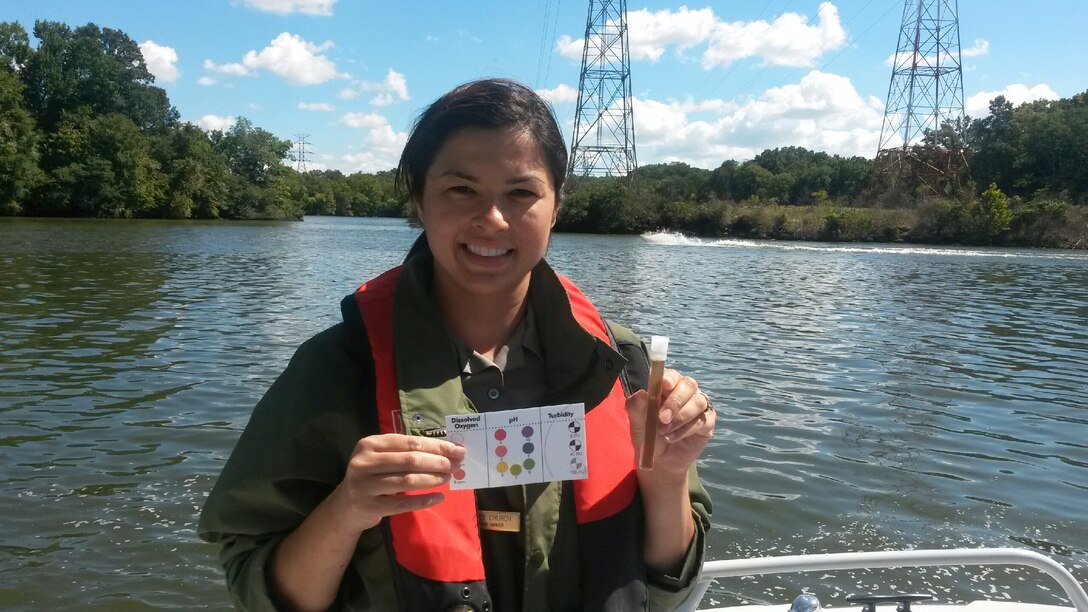 Amy Redmond, natural resource specialist at Old Hickory Lake, holds up the pH sample to the pH color chart for recording the results collected at river mile 247.7 on the Cumberland River for the 2013 World Water Monitoring Challenge™ Sept. 13, 2013.