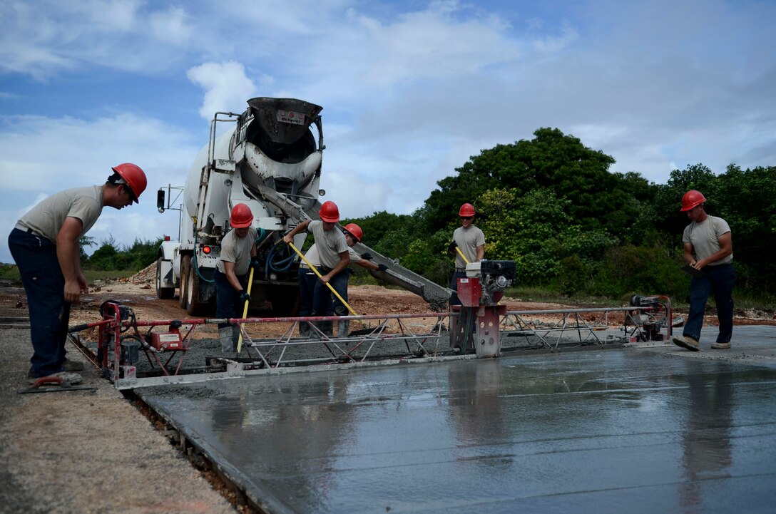 Airmen from the 554th RED HORSE Squadron float concrete Sept. 18, 2013, at the mock runway training area on Northwest Field, Guam. As part of the Silver Flag Training Facility movement from Kadena Air Base, Japan, to Guam, the mock runway is currently under construction to provide an area to train and evaluate tasks involving operations of emergency airfield lighting systems, airfield marking, mobile aircraft arresting systems and airfield damage after attack survey. (U.S. Air Force photo by Senior Airman Marianique Santos/Released)
