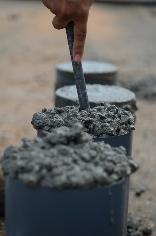Airman 1st Class Manuel Jimenez, 554th RED HORSE Squadron engineering assistant apprentice, tests the consistency and workability of concrete Sept. 18, 2013, at the mock runway training area on Northwest Field, Guam. The 554th RHS is constructing 12 projects at Northwest Field to support the Silver Flag exercise’s initial operating capabilities when they relocate here from Kadena Air Base, Japan. (U.S. Air Force photo by Senior Airman Marianique Santos/Released)