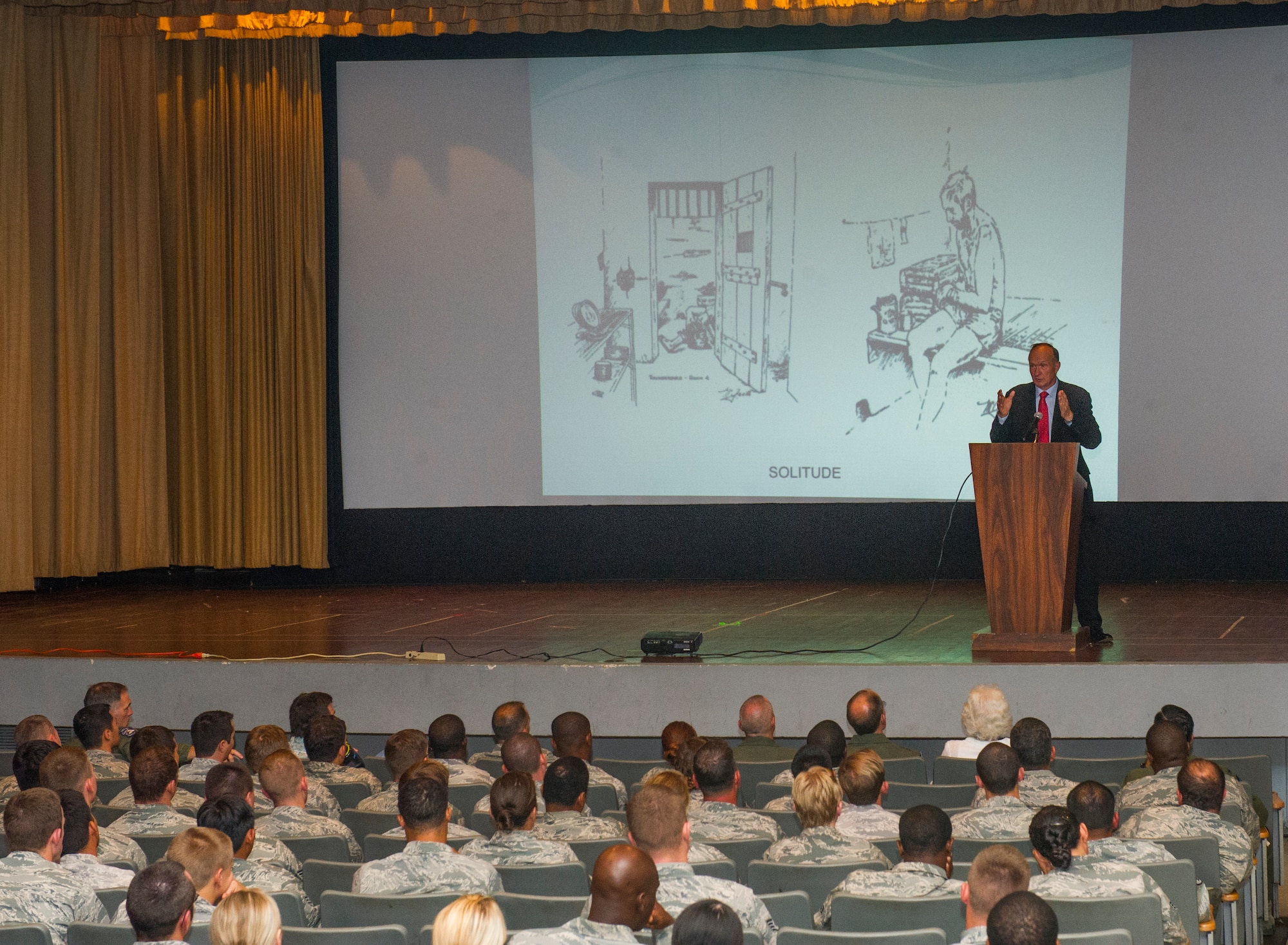 Air Force Capt. Guy Gruters, a former prisoner of war from the Vietnam War, discusses his time as a POW at a presentation September 18, 2013, at the Hickam Base Theater, Joint Base Pearl Harbor-Hickam, Hawaii. During his presentation, Gruters spoke about several topics including the importance of teamwork, leadership, communication, and the code of conduct in surviving his five-year incarceration in Northern Vietnam. (U.S. Air Force photo by Staff Sgt. Nathan Allen)