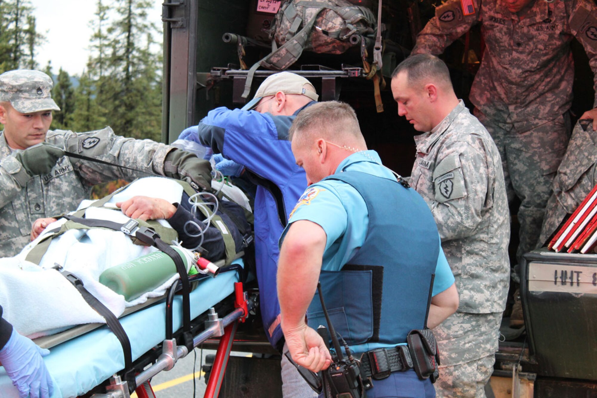 Sgt. 1st Class Ryan Wahler (far right), a senior medic with Headquarters and Headquarters Troop, 1st Squadron (Airborne), 40th Cavalry Regiment, from Fort Knox, Ky., gives emergency medical aid in partnership with fellow paratroopers and emergency personnel, to an accident victim Sept. 8. (Photo courtesy of Sgt. 1st Class Miguel A. Baltazar)