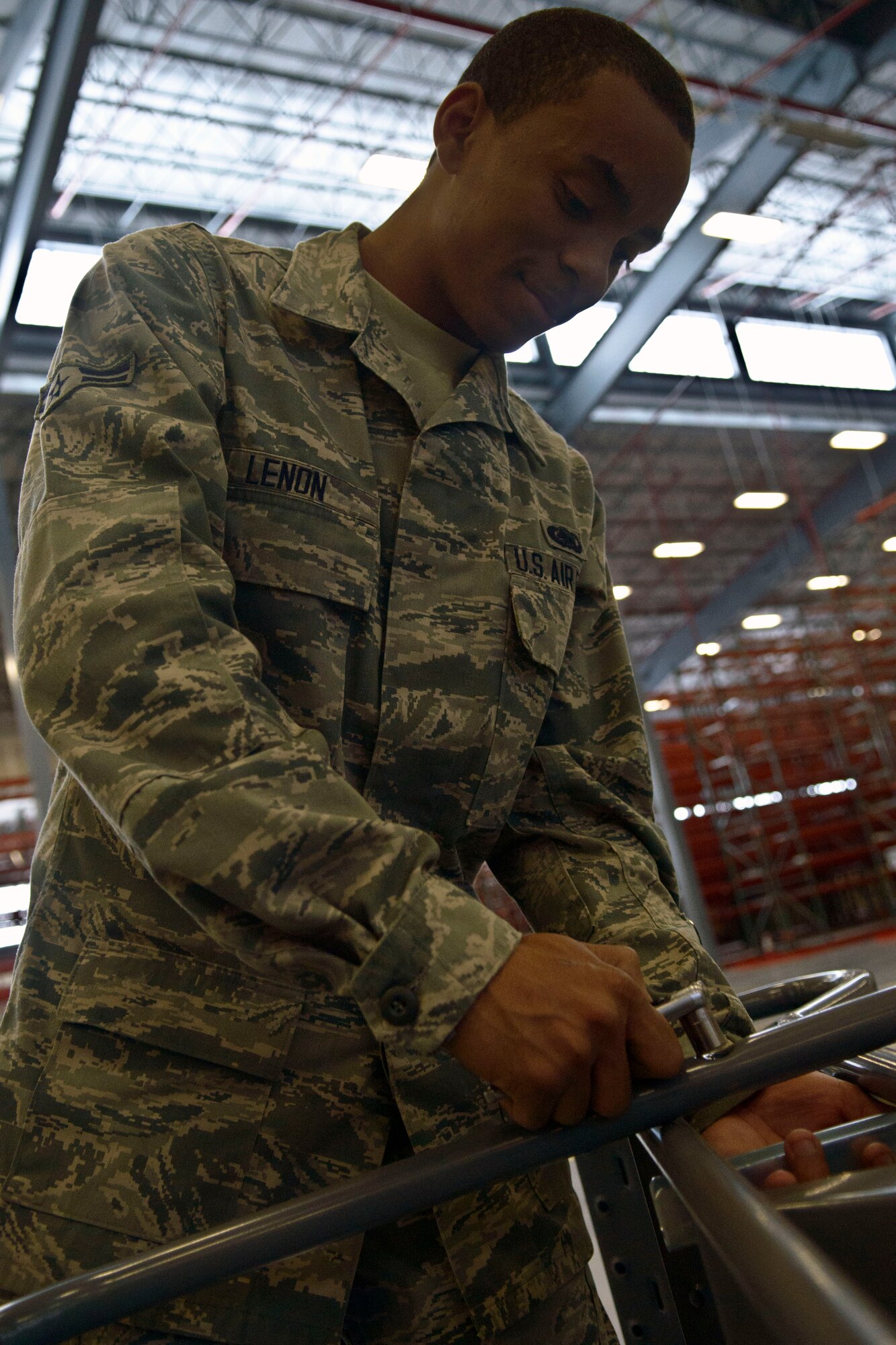 U.S. Air Force Airman 1st Class Jimaurice Lenon, a 366th Logistics Readiness Squadron material management apprentice from Pensacola, Fla., tightens down a retaining bolt at Mountain Home Air Force Base, Idaho, Sept. 19, 2013. The bolt was one of millions in a complex shelving system, which Lenon and other Airmen are assembling to complete a state-of-the-art consolidated supply warehouse, which will house F-15E Strike Eagle parts and components. Lenon and his teammates must ensure each bolt, every brace and all components are constructed correctly, as the safety of their fellow Airmen and hundreds of millions of dollars in aircraft parts rely on their precision. (U.S. Air Force photo by Master Sgt. Kevin Wallace/RELEASED)