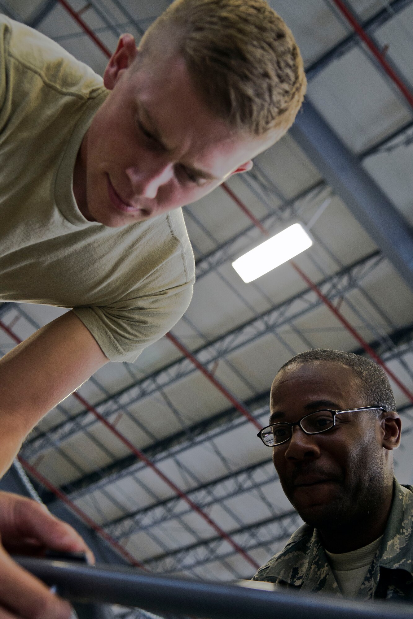 U.S. Air Force Airman 1st Class John Brantley, a Tampa, Fla., native, aligns a ladder handrail as Air Force Tech. Sgt. Harold Andrews, from Idabel, Okla., oversees the task at Mountain Home Air Force Base, Idaho, Sept. 19, 2013. Both Airmen are assigned to the 366th Logistics Readiness Squadron Material Management Flight, whose members are working overtime to complete a state-of-the-art consolidated supply warehouse, scheduled to be complete in late December 2013. Brantley, who hails from an ‘Air Force family,’ and who’s sister is also currently serving in the Air Force, is lauded by his teammates and supervisors as a motivated, go-getter Airman. (U.S. Air Force photo by Master Sgt. Kevin Wallace/RELEASED)