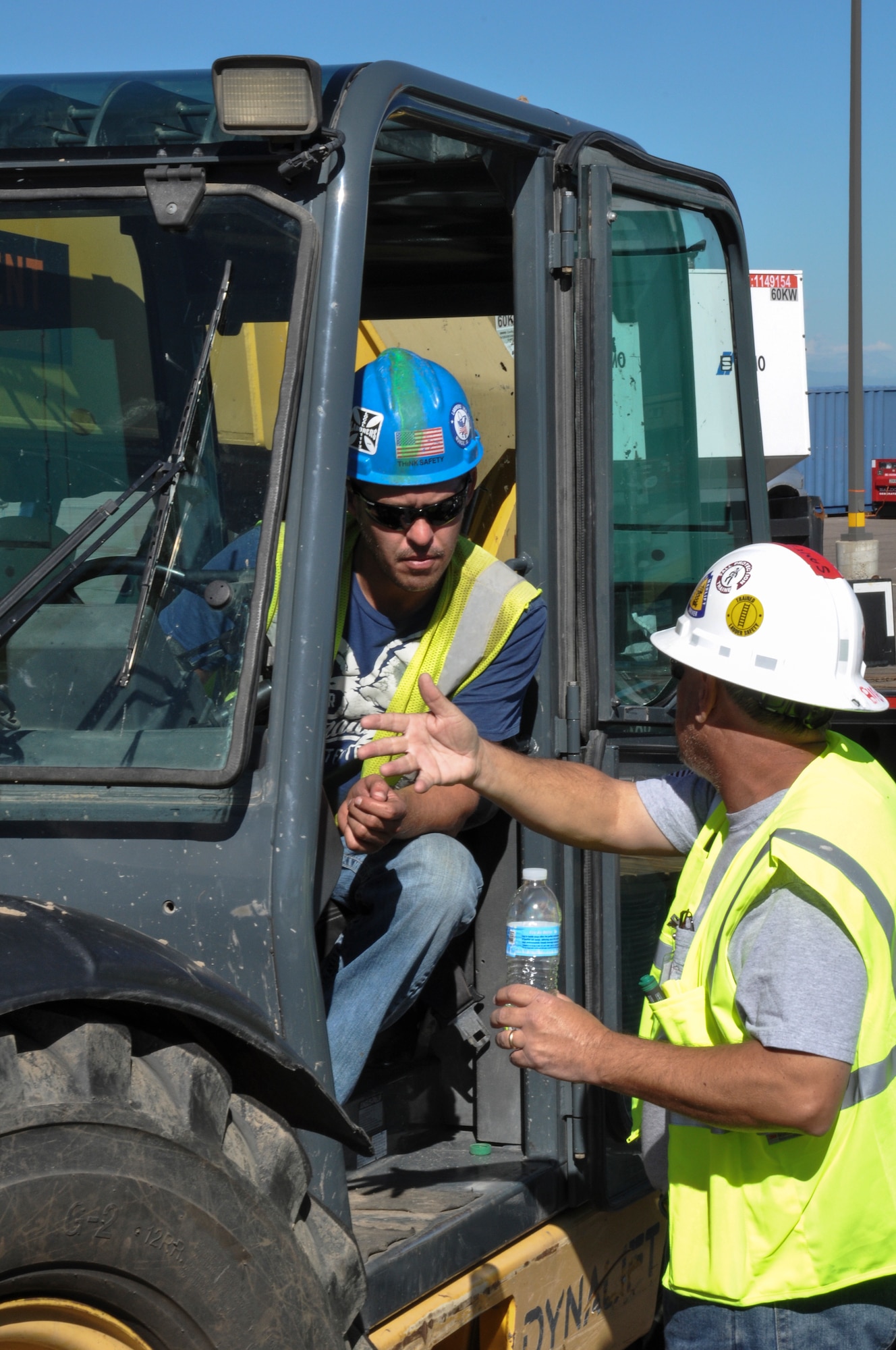 James Coleman, contractor working alongside the Army Corps of Engineers, speaks with a forklift operator before moving a shipping container Sept. 17, 2013, at Buckley Air Force Base, Colo. The contractors assisted with flood relief by fixing and maintaining generators that were used as aid during relief efforts after Colorado suffered up to 15 inches of rain that caused massive flooding across the Front Range. (U.S. Air Force photo by Staff Sgt. Nicholas Rau/Released)