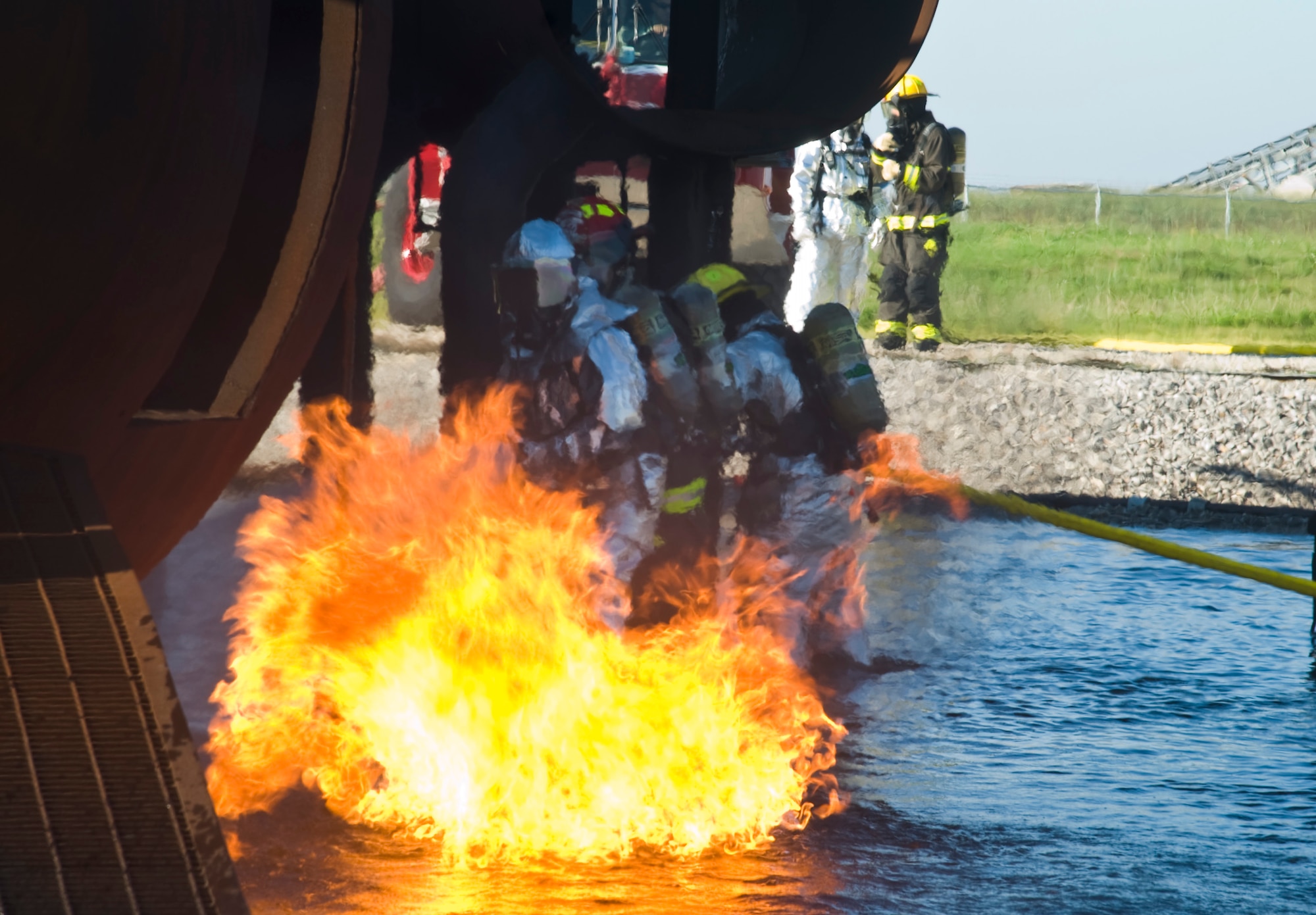 Senior Master Sgt. Vegas Clark, 22nd Mission Support Group superintendent, fights a controlled fire with firefighters from the 22nd Civil Engineering Squadron Aug. 27, 2013, at McConnell Air Force Base, Kan. The firefighters guided Clark and leaders through extinguishing several types of aircraft-fire scenarios. Fire training exercises are performed to help firefighters remain proficient with their skills and test the functionality of their equipment. (U.S. Air Force photo/Airman 1st Class John Linzmeier)