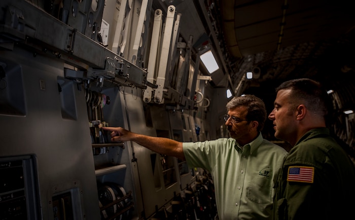 (Right) Ret. Chief Master Sgt. Bob Morris, C-17 Training Systems Charleston lead loadmaster, explains to his son, Tech. Sgt. Mike Morris, 437th Airlift Wing Operations Group standards and evaluations loadmaster, the modifications of the C-17 Globemaster III Sept. 17, 2013 at Joint Base Charleston – Air Base, S.C. Bob is a retired loadmaster and was on the plane for the arrival of the first C-17 delivered to the Air Force in June 1993. (U.S. Air Force photo / Senior Airman Tom Brading)