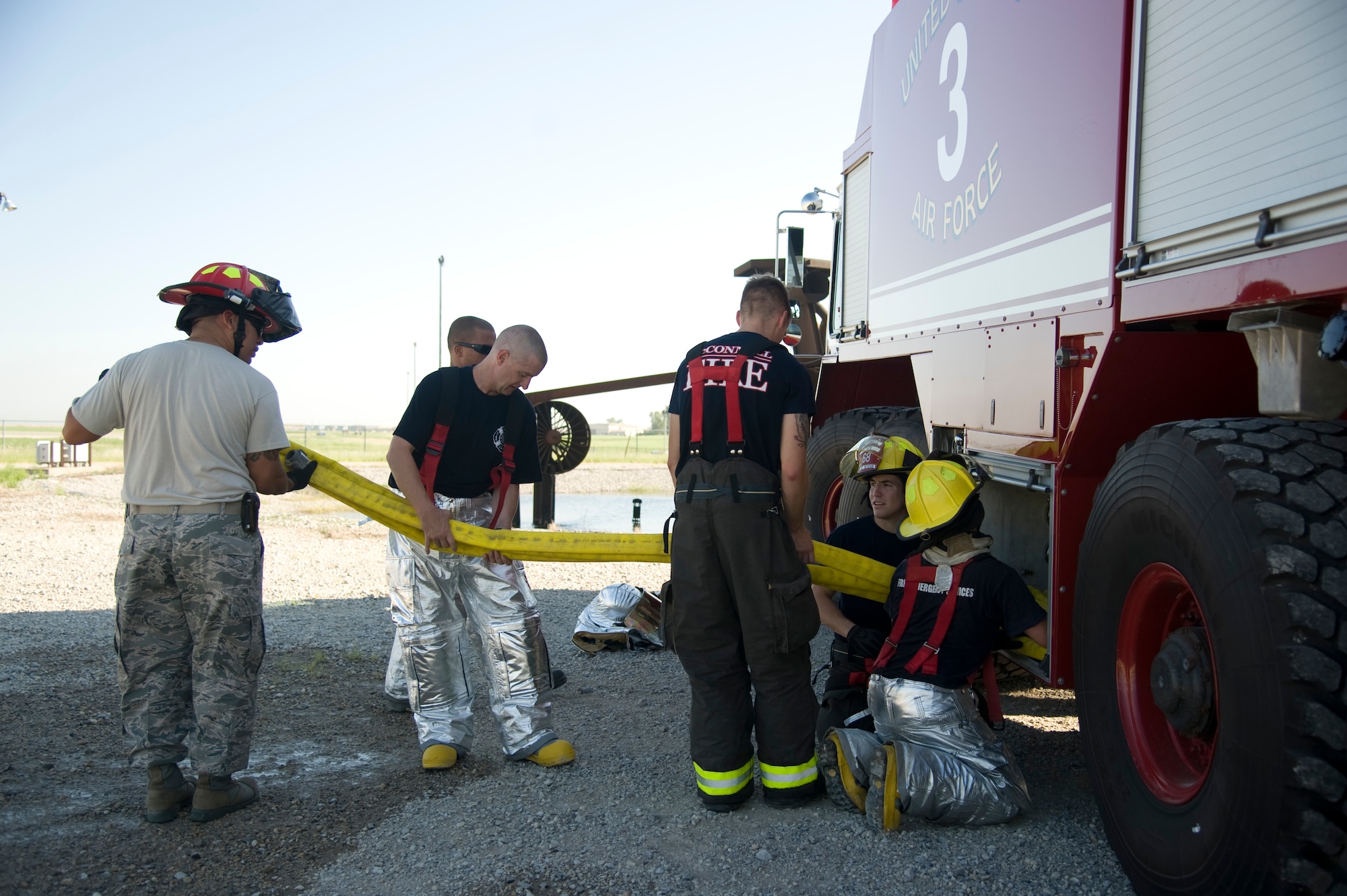 Firefighters from the 22nd Civil Engineering Squadron load a fire attack hose into a driver’s side pump compartment Aug. 27, 2013, at McConnell Air Force Base, Kan. The hose is carefully stowed to prevent kinks that may stop the flow of water.  (U.S. Air Force photo/Airman 1st Class John Linzmeier)