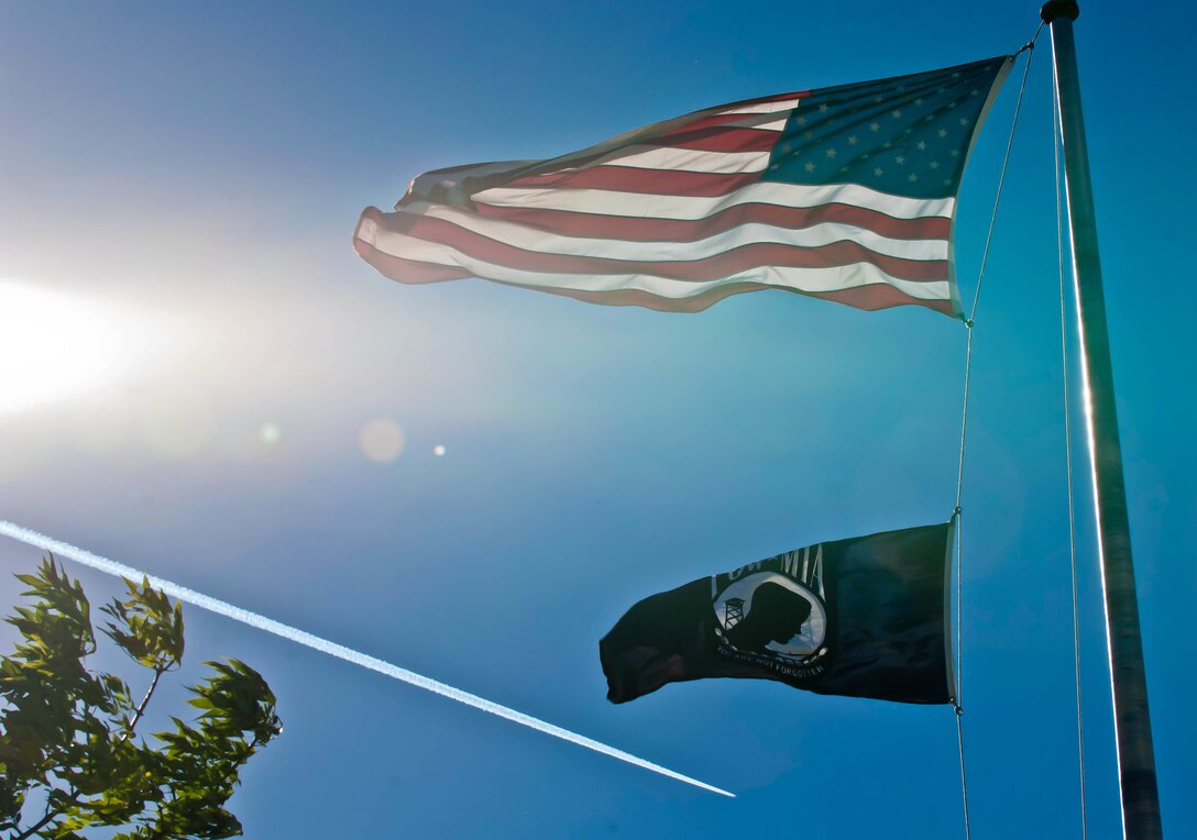 The U.S. and POW/MIA flags fly on the base flagpole in front of the 28th Bomb Wing Headquarters building at Ellsworth Air Force Base, S.D., Sept. 20, 2012. Ellsworth will conduct a retreat at the base flagpole Sept. 20, as part of POW/MIA Day. (U.S. Air Force photo by Airman 1st Class Zachary Hada/Released)
