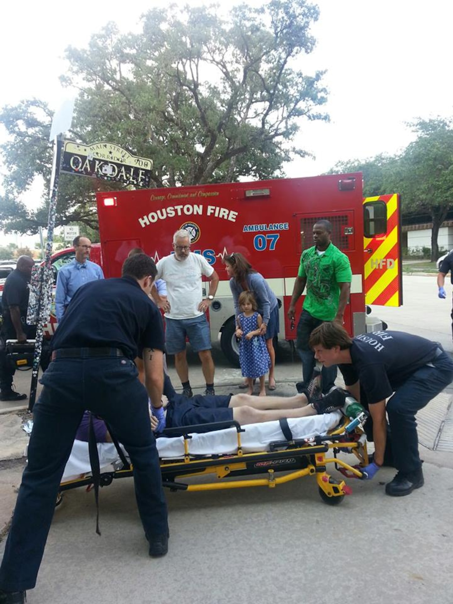(In green) Air Force Staff Sgt. Robert Niter III, 47th Medical Operations Squadron NCO in charge of optometry, looks on as members from the Houston Fire Department prepare to load a patient into their ambulance Sept. 12, 2013, in Houston. Niter, was on leave, when he noticed a downed-man with a crowd of people around him while driving that afternoon. Niter and his girlfriend immediately responded to the man before beginning life saving techniques for nearly 30 minutes until emergency management services arrived. The unknown man was stabilized and is doing well, according to the HFD, all due to Niters selfless actions. (Courtesy photo)