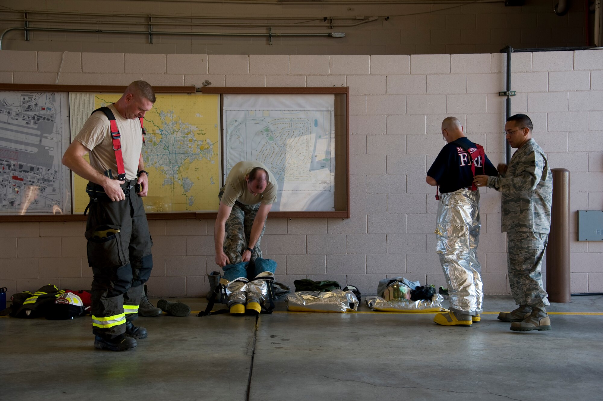 Leadership from the 22nd Civil Engineering Squadron don personal protective equipment to participate in a live fire training exercise Aug. 27, 2013, at McConnell Air Force Base, Kan. Firefighters conduct head-to-toe inspections on their gear daily. (U.S. Air Force photo/Airman 1st Class John Linzmeier)