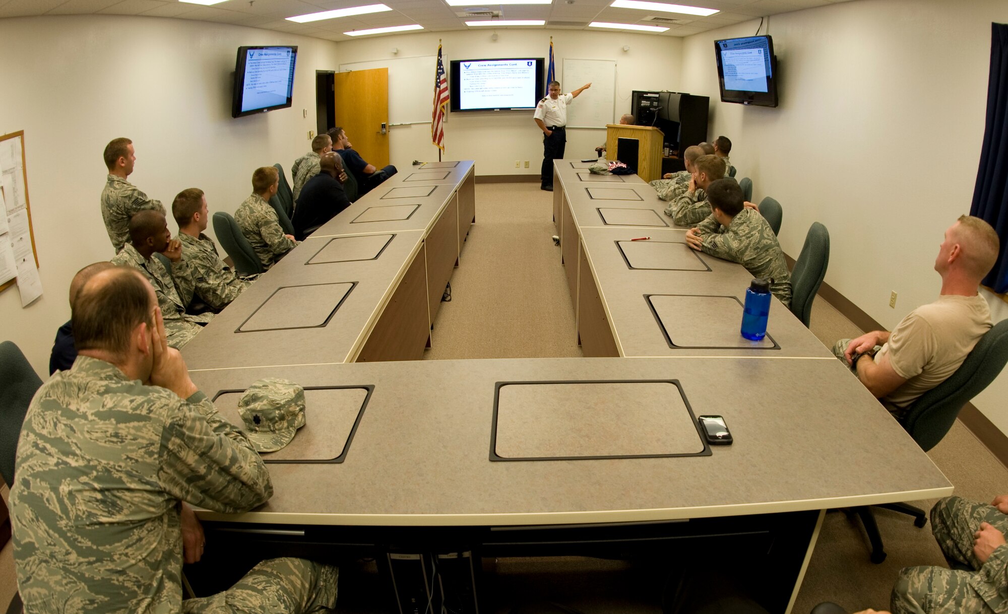 Firefighters from the 22nd Civil Engineering Squadron listen to a briefing from Edward Sanches, 22nd CES assistant fire chief, before a live-fire training exercise Aug. 27, 2013, at McConnell Air Force Base, Kan. Safety precautions and benchmarks such as proper tuck positioning and fire extinguishing methods are briefed before every live exercise. (U.S. Air Force photo/Airman 1st Class John Linzmeier)