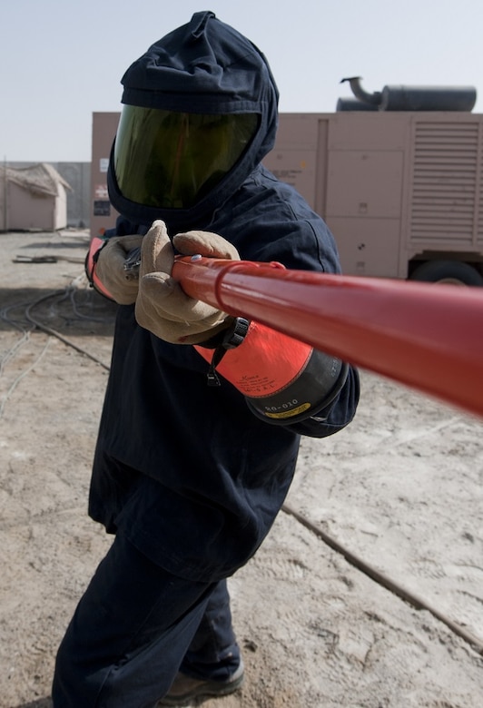 U.S. Air Force Senior Airman Tim Radke, 380th Expeditionary Civil Engineer Squadron electrical systems journeyman, uses an insulated grip-all hot stick to replace a plug on a generator at an undisclosed location in Southwest Asia, Sept. 11, 2013. When power is live, electrical systems technicians are required to wear an arc flash suit due to the possibility of an electrical arc flash occurring. Radke calls Citrus County, Fla., home and is deployed from Joint Base McGuire-Dix-Lakehurst, N.J (U.S. Air Force photo by Staff Sgt. Jacob Morgan/Released)