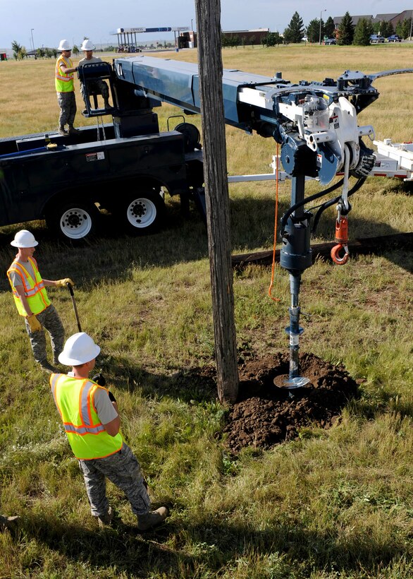 Airman 1st Class Nikko Manga, 28th Civil Engineer Squadron electrical systems technician, controls an auger to dig a hole for a new utility pole during an equipment upgrade at Ellsworth Air Force Base, S.D., Sept. 13, 2013. The hole was dug near an old utility pole in an effort to expedite the transfer of new poles with LED lamps and electrical wiring. (U.S. Air Force photo by Airman 1st Class Anania Tekurio/Released)