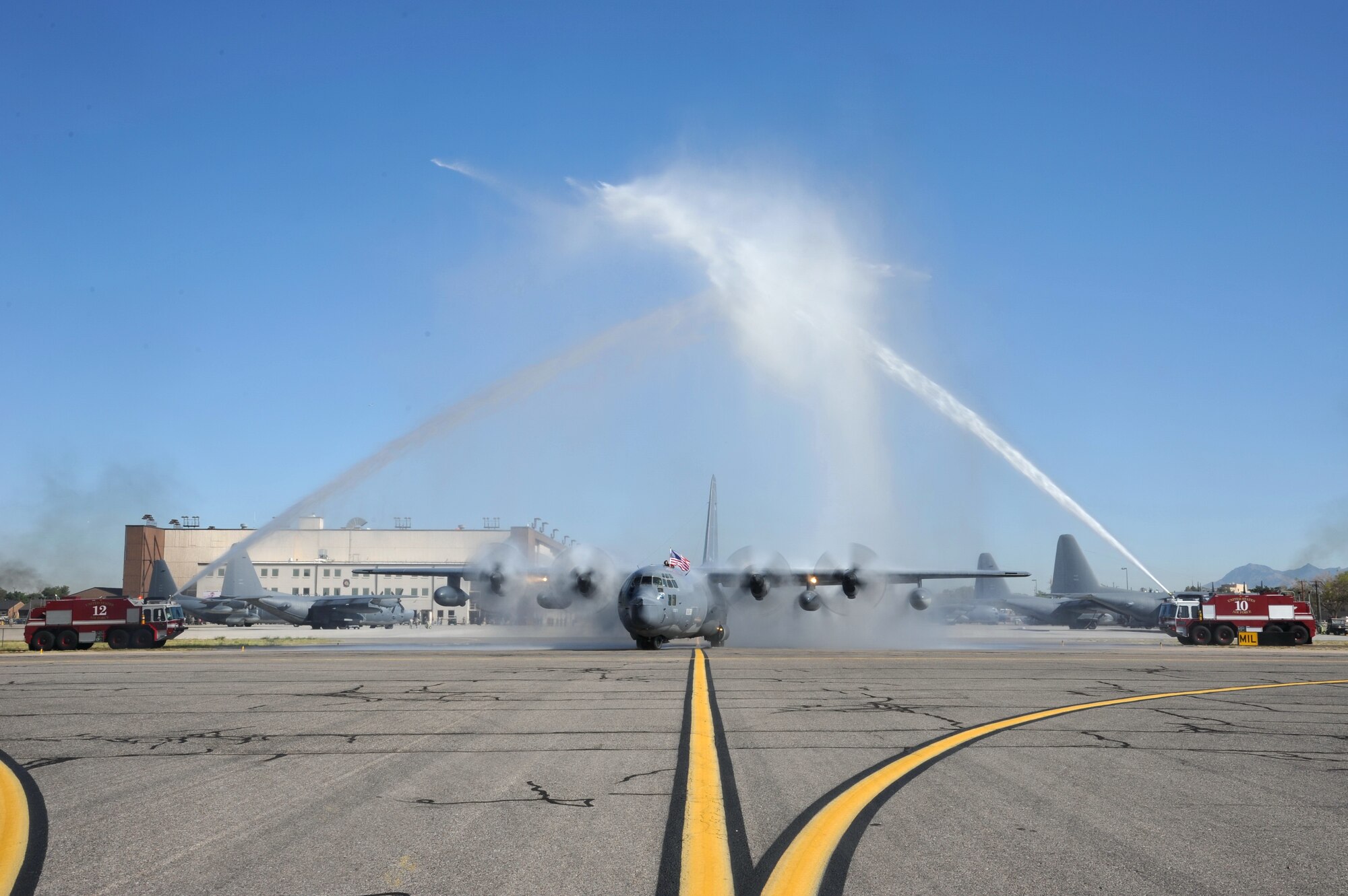 Firefighters give a water salute to one of the 550th Special Operations Squadron's last two remaining assigned MC-130Ps Combat Shadows as it taxis the runway in preparation for its final flight Sept. 6.  The departure of the aircraft marks the end of a 25-year training curriculum at Kirtland. (Photo by Ken Moore)