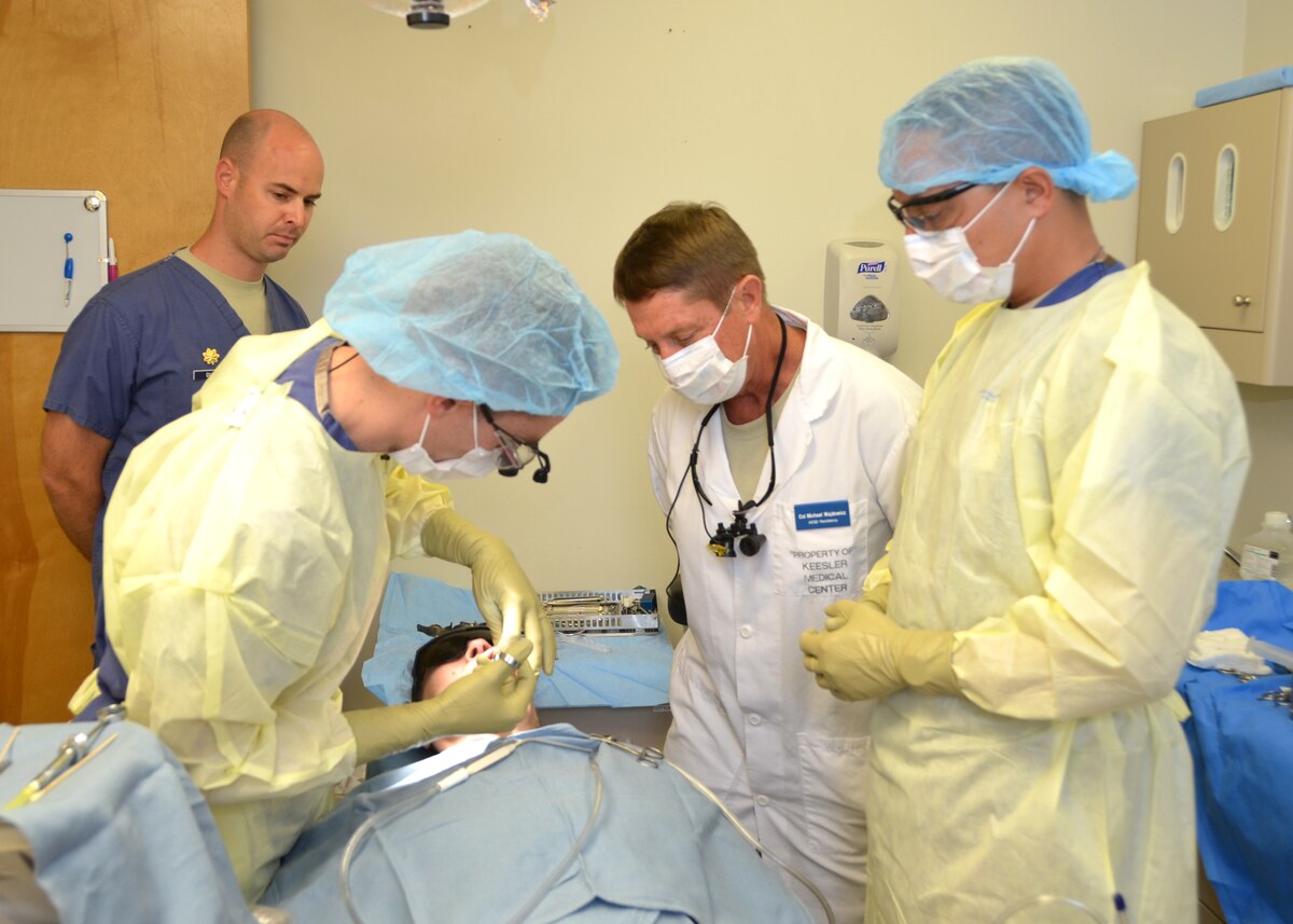 Col. (Dr.) Michael Wajdowicz, the two-year Advanced Education in General Dentistry Residency Program director, second from right, observes resident Capt. (Dr.) Aaron Hayes, left, as he prepares a patient for surgery Sept. 4 with the aid of dental technician Staff Sgt. David Reimer, right.  Maj. (Dr.) Nicholas Duvall, the program’s training officer, watches the procedure and asks Hayes questions related to patient care. (U.S. Air Force photo by Steve Pivnick)