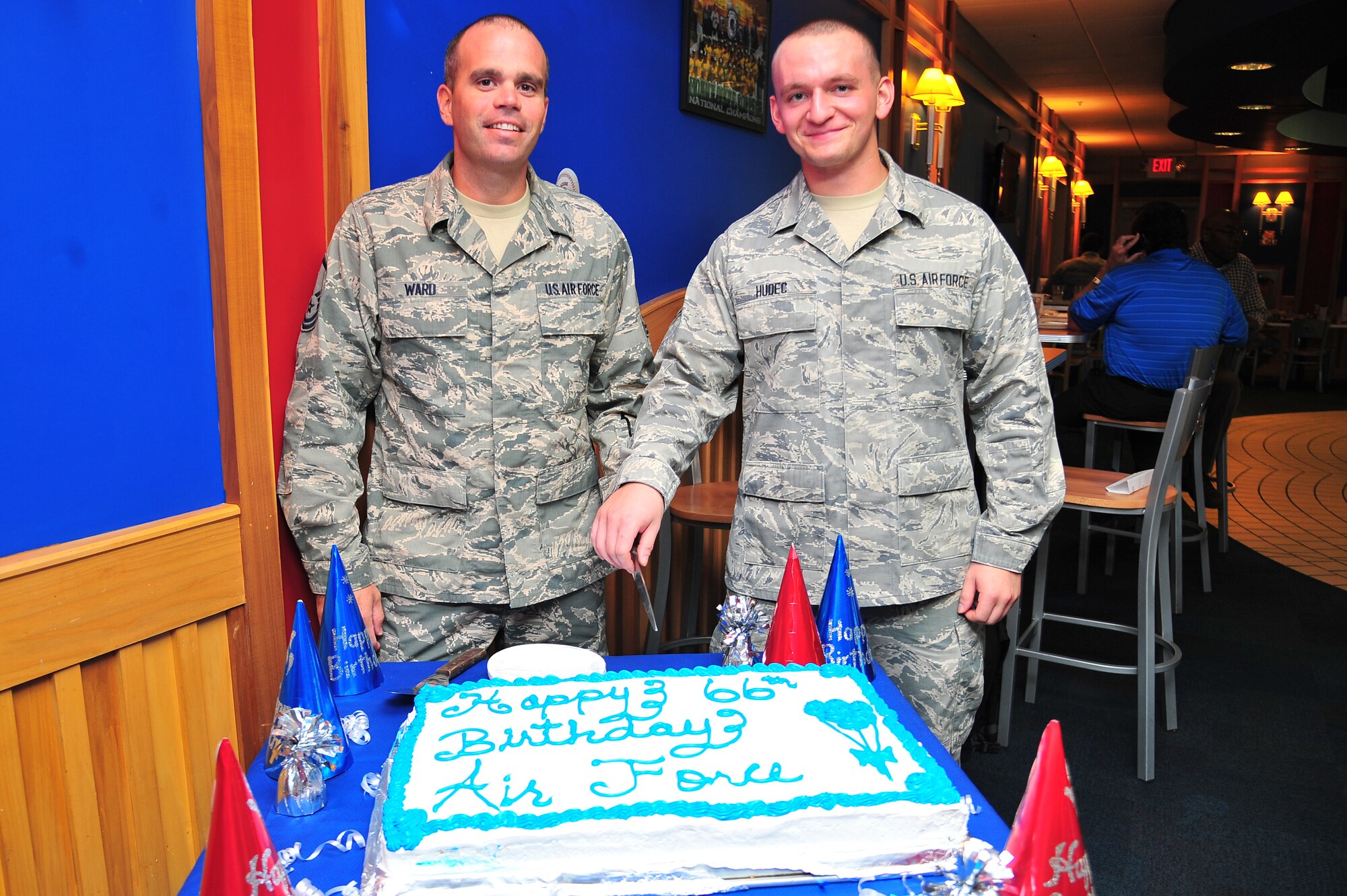 U.S. Air Force Master Sgt. Lance Ward, 4th Force Support Squadron manpower analyst, and Airman Jordan Hudes, 4th FSS food services apprentice, smile as they prepare to cut an Air Force birthday cake at Seymour Johnson Air Force Base, N.C., Sept. 19, 2013. For the last 66 years, America has depended on Airmen who provide Global Vigilance, Global Reach and Global Power, never failing to answer the Nation’s call. (U.S. Air Force photo by Senior Airman Aubrey White/Released)