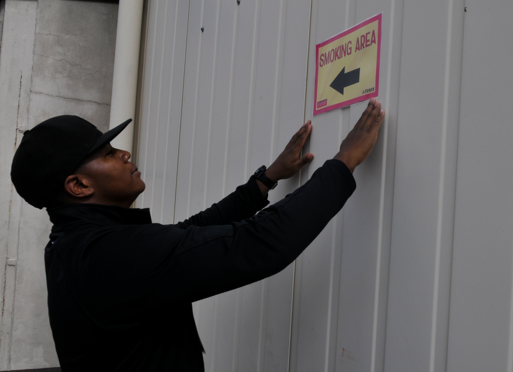 Staff Sgt. Marcus Wilson, 721st Aerial Port Squadron special handling superintendent, hangs a sign before the bazaar, Sept. 10, 2013, Ramstein Air Base, Germany. Volunteers handled things like setting up tables and benches to displaying directional signs to guide visitors to the bazaar. (U.S. Air Force photo/Senior Airman Jose L. Leon)