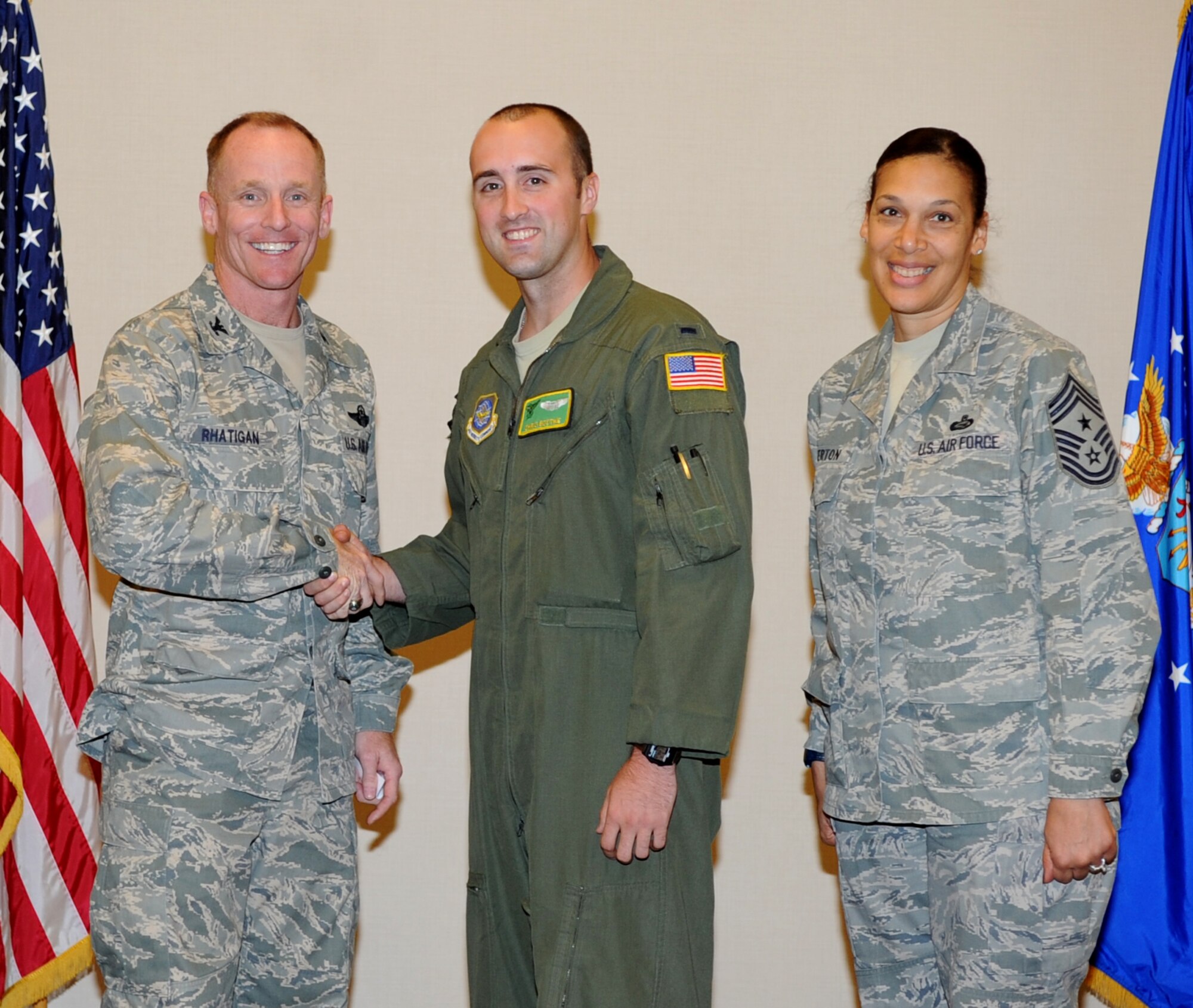Col. Patrick Rhatigan, 19th Airlift Wing commander, and Chief Master Sgt. Margarita Overton, 19th AW command chief, congratulate 1st Lt. Christopher Bodtke, a 61st Airlift Squadron co-pilot, for being selected as the Combat Airlifter of the Week Sept. 16, 2013, at Little Rock Air Force Base, Ark. Bodtke, a Colorado Springs, Co. native, was selected for excelling in joint training, acting as interim chief of mobility and deploying personnel in support of Operation Enduring Freedom. Bodtke also led the squadron to a high pass rate for their physical fitness test and prepared 151 sorties for joint and international training with Canadian and New Zealand forces. (U.S. Air Force photo by Staff Sgt. Caleb Pierce) 