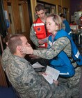 HANSCOM AIR FORCE BASE, Mass. – Capt. Jaime Robey, 66th Medical Squadron physician, treats Senior Airman Richard Riggleman during a scenario at a disease containment base readiness exercise at the Youth Center Sept. 18. The exercise scenario called for patients to show up with symptoms of meningitis that evaluated the 66th Medical Squadron’s response to the outbreak. (U.S. Air Force photo by Rick Berry)