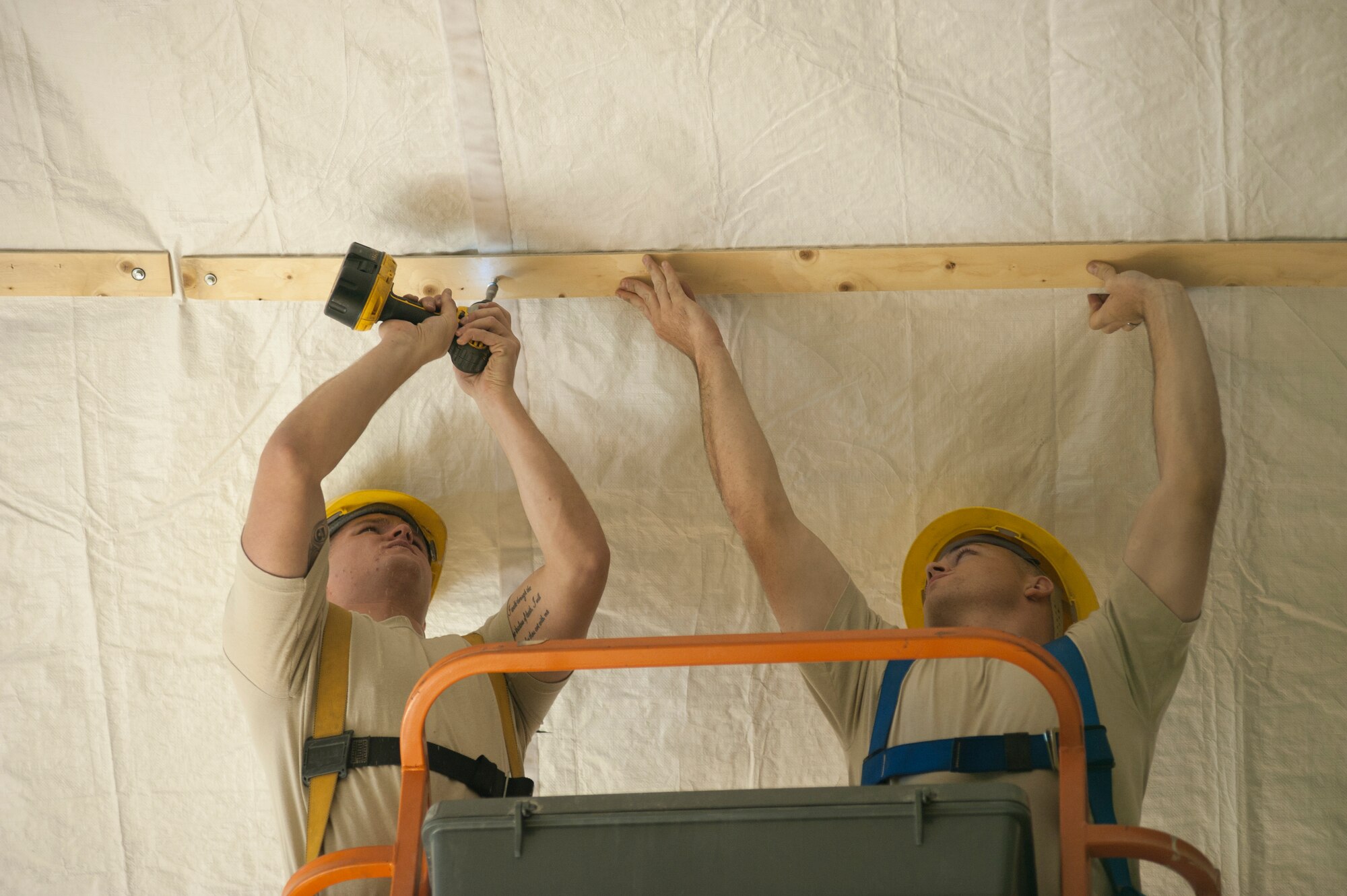 Airman 1st Class Larry Finch, left, and Airman 1st Class Chad Chapman, 376th Expeditionary Civil Engineer Squadron structural engineers, secure insulation into the ceiling of the main fitness center annex at Transit Center at Manas, Kyrgyzstan, Sept. 6, 2013. Chapman is deployed out of Altus Air Force Base, Okla., and is a native of Shelton, Wash. Finch is also deployed out of Altus Air Force Base, Okla., and is a native of Aztec, N.M. (U.S. Air Force photo/Staff Sgt. Robert Barnett)