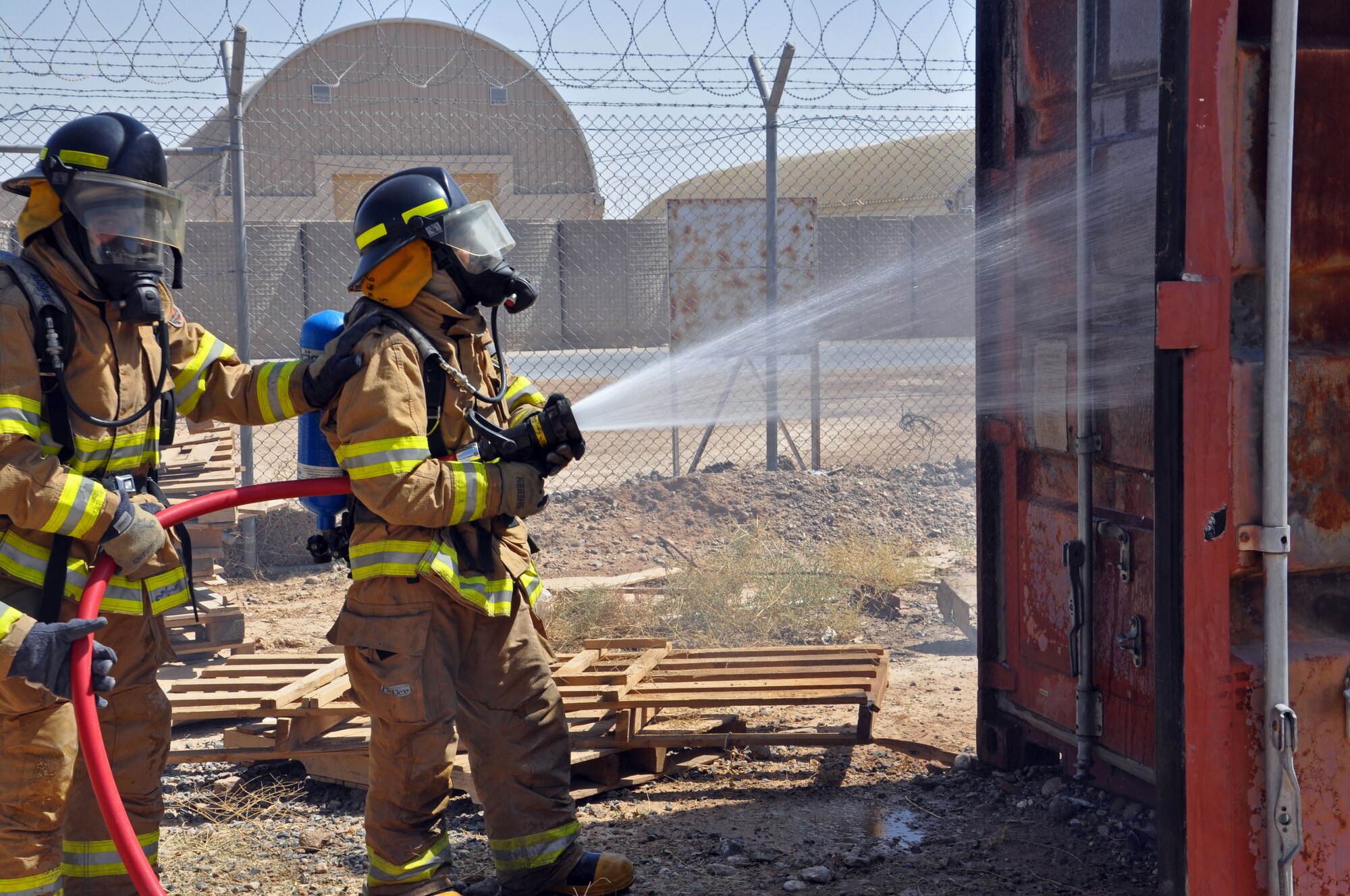 Afghan Air Force fire fighters prepare to enter a burning building as part of an exercise Sept. 8, 2013 at Kandahar Airfield, Afghanistan. During 2013, advisors with NATO Air Training Command-Afghanistan, have begun to step away from training as the Afghans themselves begin to take over both training and operations of the fire department. (U.S. Air Force photo/Capt. Anastasia Wasem)