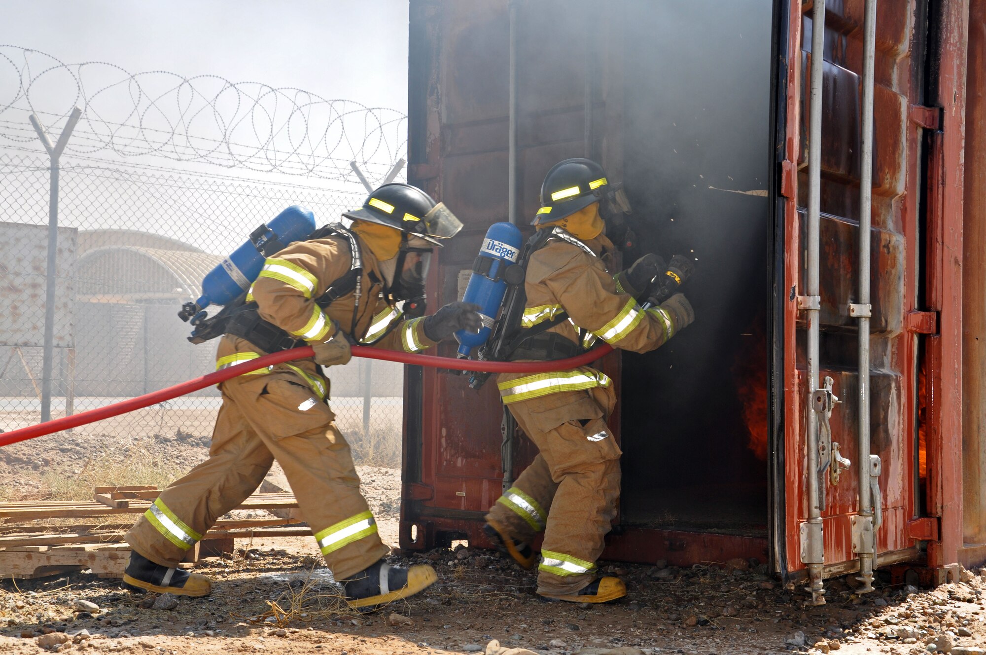 Afghan Air Force fire fighters rush into a burning building as part of an exercise Sept. 8, 2013 at Kandahar Airfield, Afghanistan. The Kandahar Air Wing Fire Department has seen substantial changes and improvements in recent months as the Afghans continue to take over more of the training and operations. (U.S. Air Force photo/Capt. Anastasia Wasem)