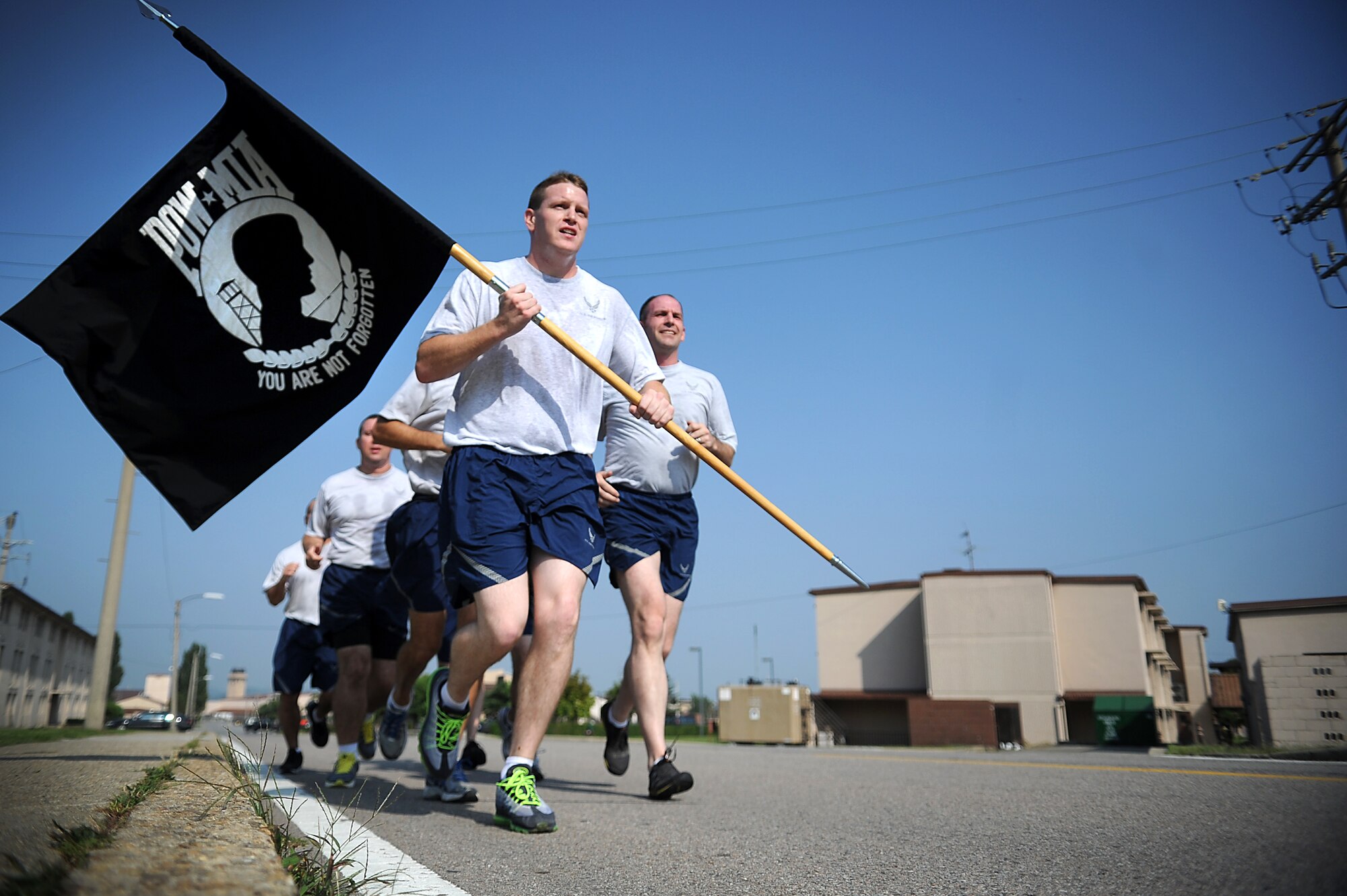 Airmen from the 51st Maintenance Operations Flight run in formation with the official Prisoner of War/Missing in Action flag as part of a 24-hour run during POW/MIA week at Osan Air Base, Republic of Korea, Sept. 18, 2013. Osan recognized POW/MIA Day throughout the week of Sept. 16 to 19 with multiple events, including a candlelight vigil, a 24-hour run, and reveille and retreat ceremonies. (U.S. Air Force photo/Staff Sgt. Sara Csurilla)