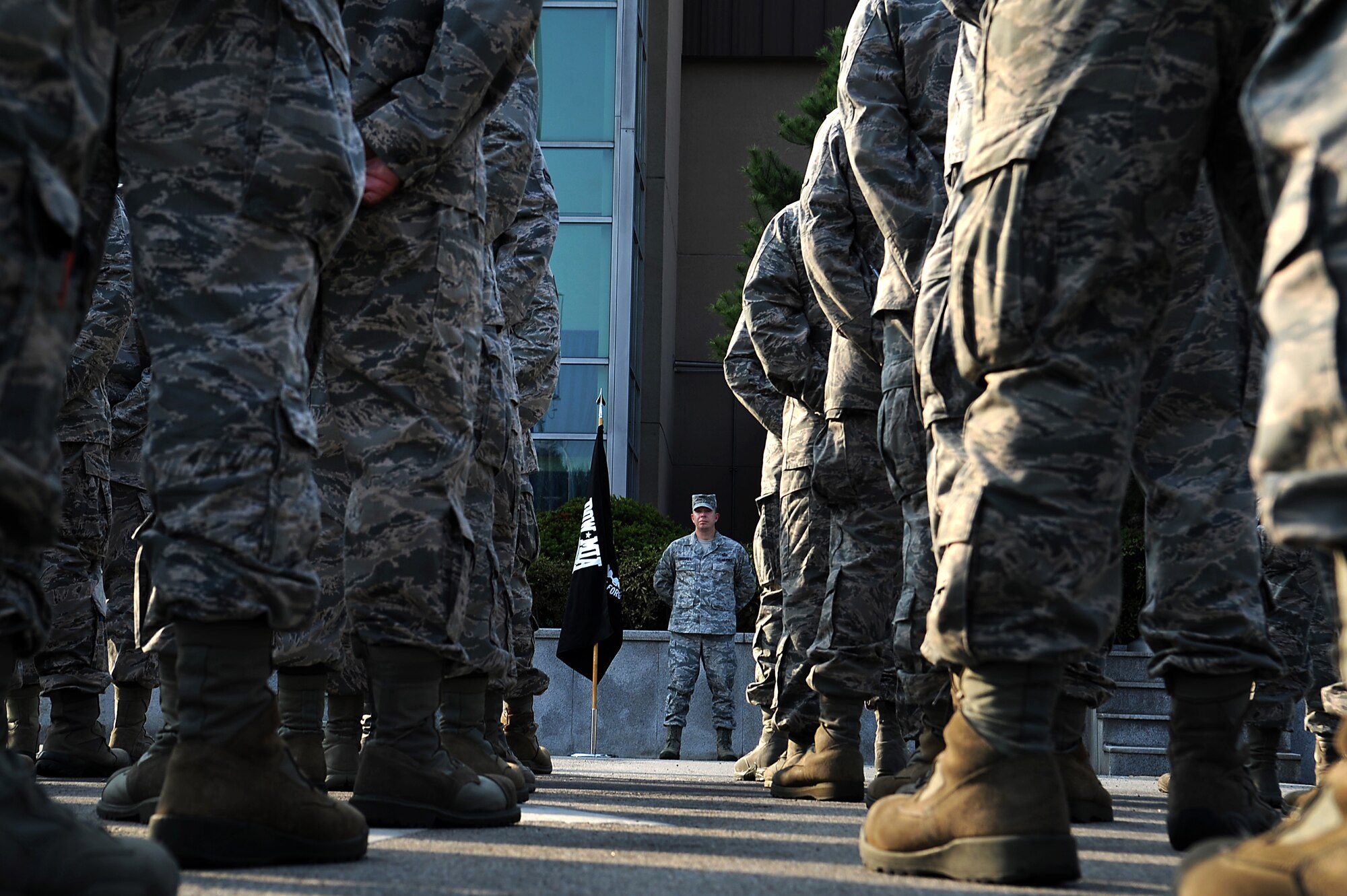 Chief Master Sgt. Brendan Criswell, 51st Fighter Wing command chief, stands next to the Prisoner of War/Missing in Action flag during a retreat ceremony to honor National POW/MIA Recognition Day at Osan Air Base, Republic of Korea, Sept. 18, 2013. The POW/MIA flag was first recognized by Public Law 101-355 in 1990, and can only be flown six days out of the year. (U.S. Air Force photo/Staff Sgt. Sara Csurilla)