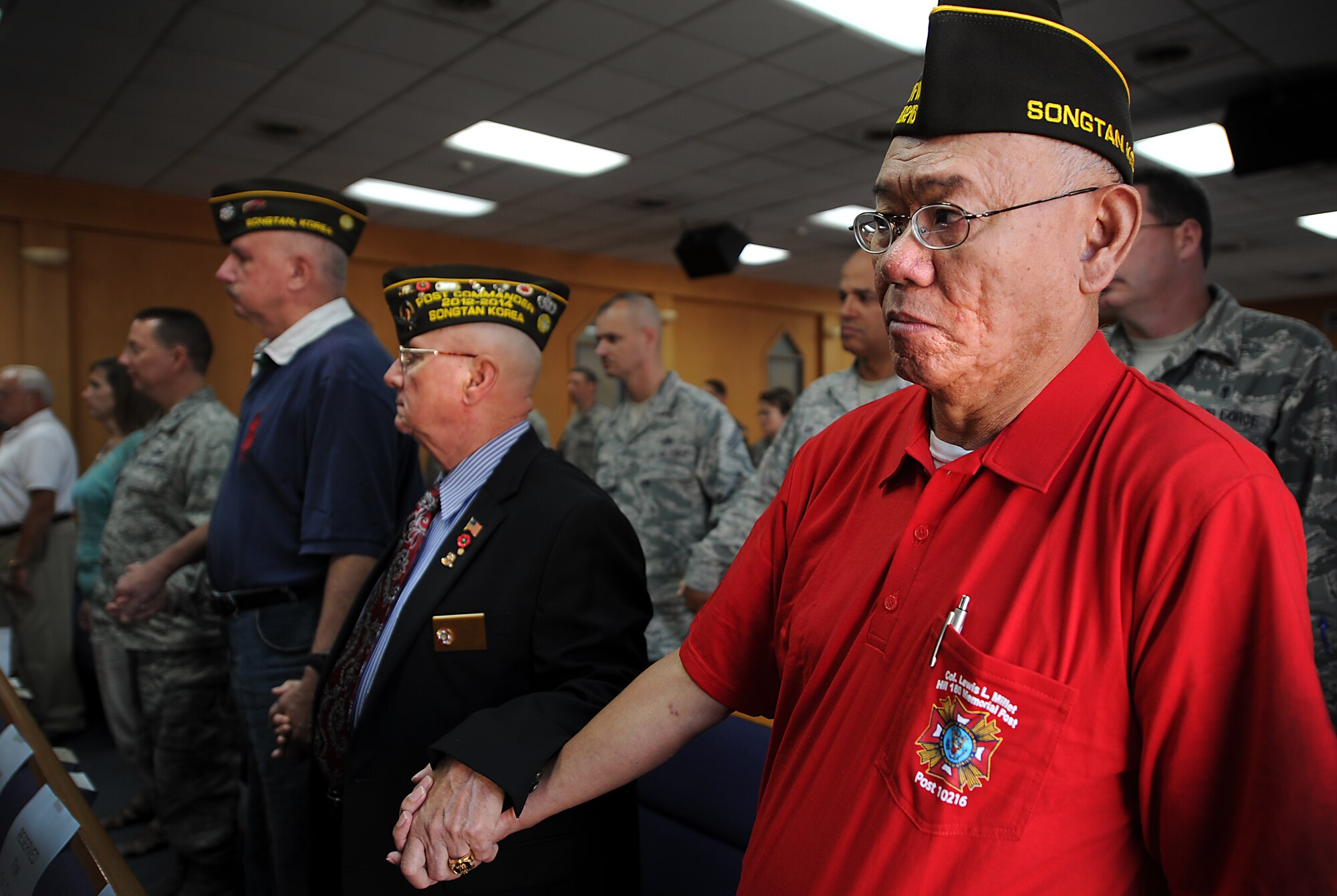 U.S. veterans from the Veterans of Foreign Wars Post 10216 of Songtan, Republic of Korea, hold hands as candles are lit and the names of U.S. service members who are still missing in action are read aloud during a candlelight vigil to recognize National Prisoner of War/Missing in Action Day at the base chapel on Osan Air Base, ROK, Sept. 18, 2013. This year’s National POW/MIA Recognition Day is Sept. 20, one of only six days the POW/MIA flag can be flown. (U.S. Air Force photo/Staff Sgt. Sara Csurilla)