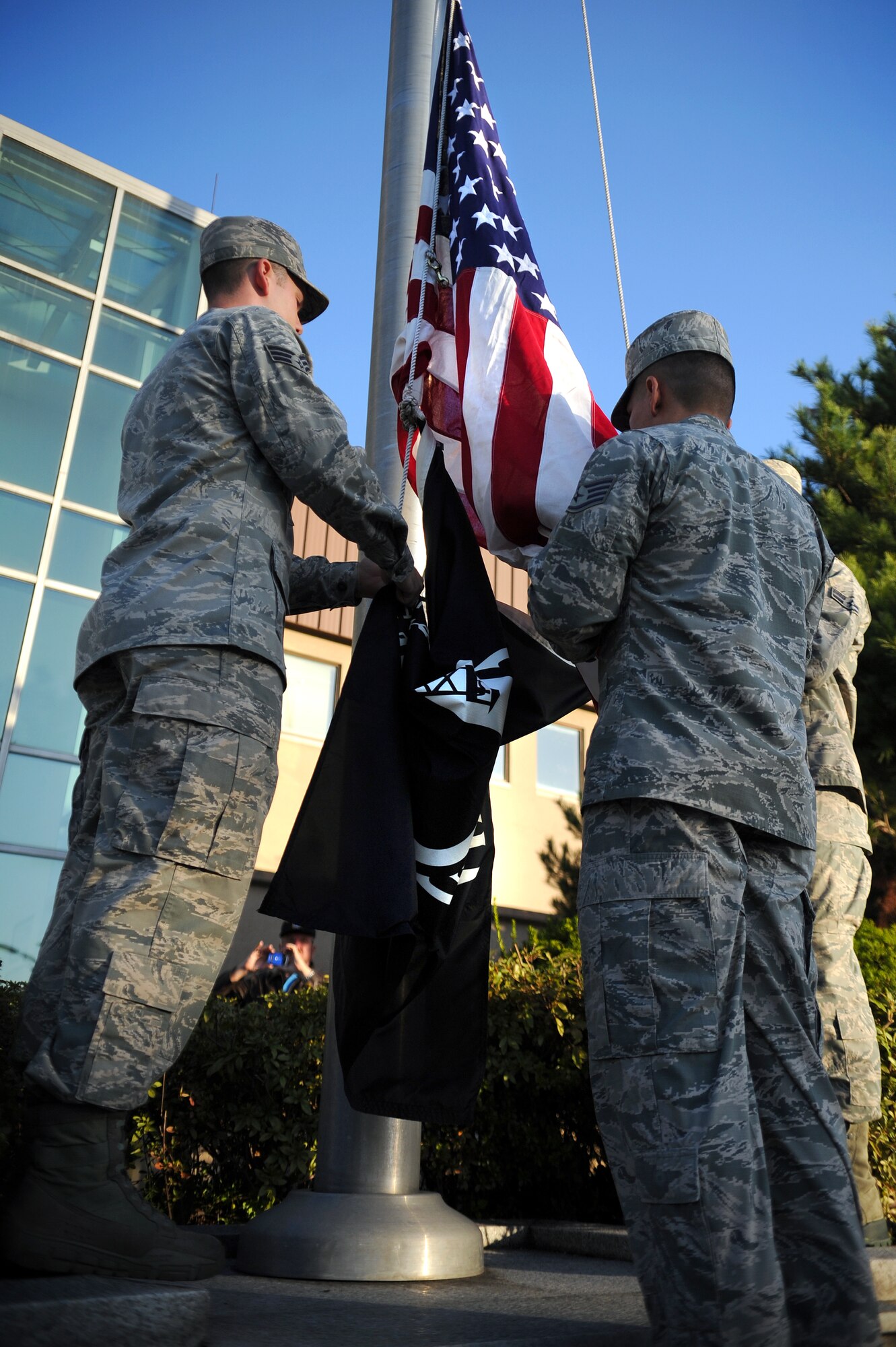 Osan Honor Guardsmen prepare to raise the American and Prisoner of War/Missing in Action flags during a reveille ceremony to kick off POW/MIA week at Osan Air Base, Republic of Korea, Sept. 17, 2013. Every year, National POW/MIA Recognition Day is observed on the third Friday in September to honor those who were prisoners of war and those who are still missing in action. (U.S. Air Force photo/Staff Sgt. Sara Csurilla)