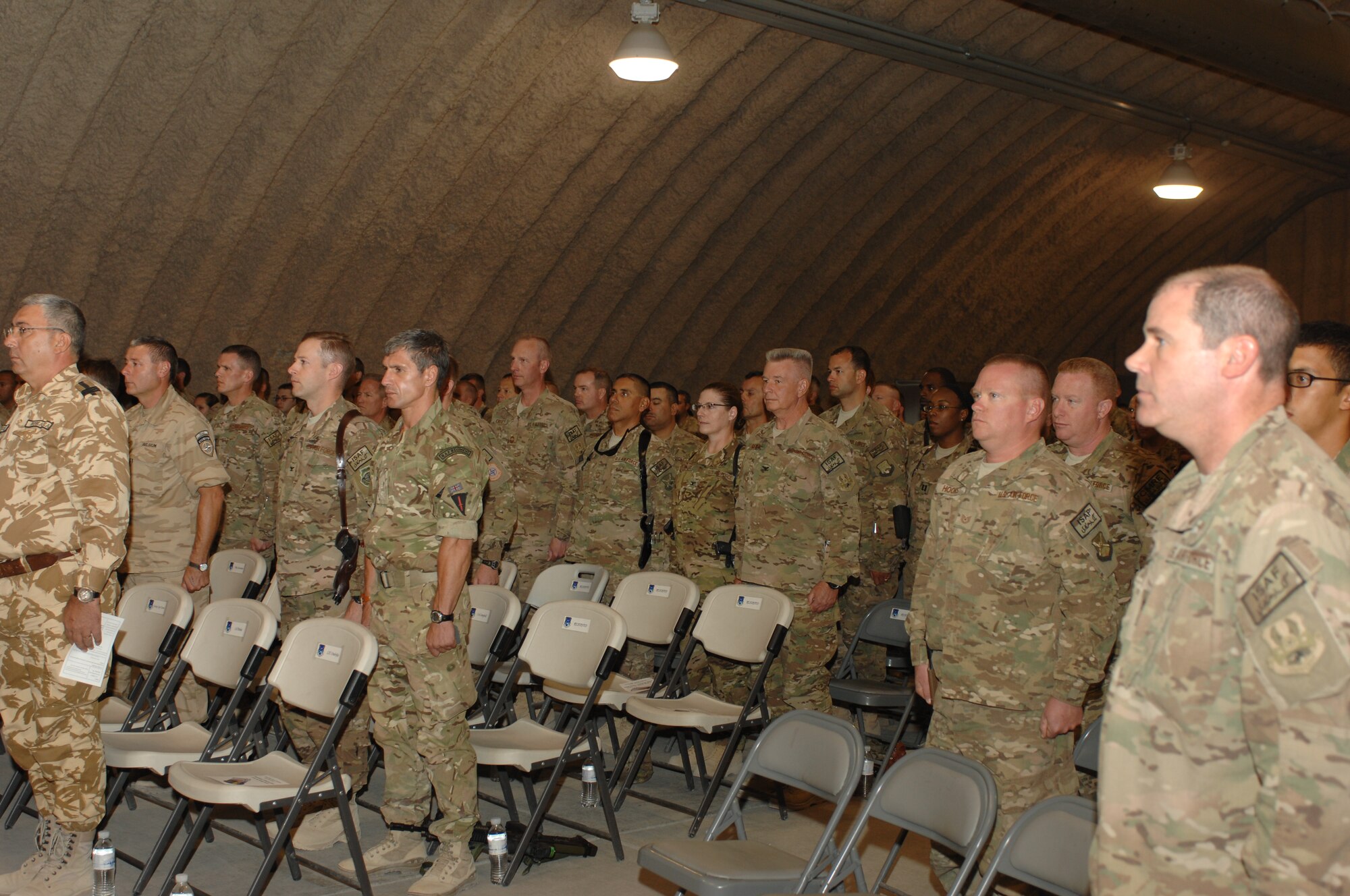 American, British and Belgian airmen, and Romanian soldiers, stand at attention as the Honor Guard presents the colors at the start of a ceremony celebrating the Air Force’s 66th birthday at Kandahar Airfield, Afghanistan. During his remarks, Brig. Gen. John Dolan, 451st Air Expeditionary Wing and Kandahar Airfield commander, noted how important the month of September is to many different Airmen, as the British recently commemorated the height of the Battle of Britain and the Airmen named the Few after Churchill’s words “Never in the field of human conflict has so much been owed by so many, to so few.” (U.S. Air Force photo/Senior Airman Jack Sanders)