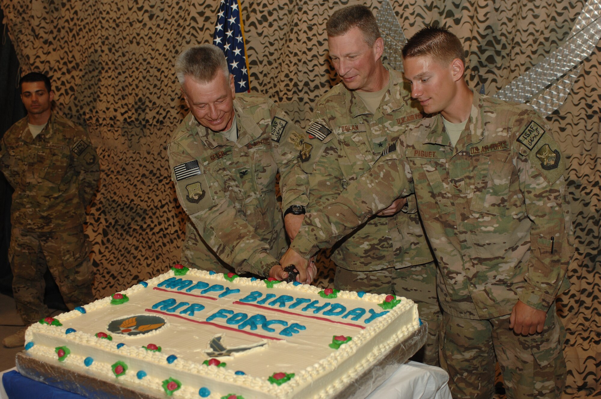 (From left) Col. David Geyer, 451st Air Expeditionary Wing Surgeon General, Brig. Gen. John Dolan, 451st AEW commander, and Airman 1st Class Adam Piguet, join together to slice the first piece of cake on the Air Force's 66th birthday celebration Sept. 18, 2013 at Kandahar Airfield, Afghanistan. It is tradition for the oldest Airman, youngest Airman and wing commander to cut the first slices of cake at the Air Force birthday celebration. (U.S. Air Force photo by Senior Airman Jack Sanders)