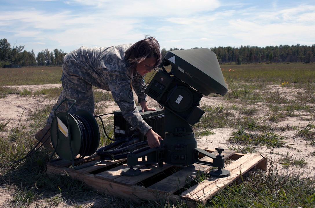 Army Spc. Katrinna Arnett sets up a Tactical Automatic Landing System for the RQ-7B Shadow Unmanned Aerial System on Jefferson Proving Ground, near Madison, Ind., Sept. 17, 2013.