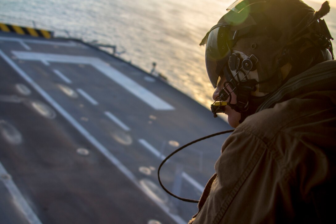 U.S. Marine Corps Sgt. Daniel Megleo assigned to Marine Medium Tiltrotor Squadron (VMM) 226 (Reinforced), 26th Marine Expeditionary Unit (MEU), helps guide an MV-22B Osprey while landing on the flight deck of the HMS Illustrious (R06), at sea, Sept. 16, 2013. The 26th MEU is a Marine Air-Ground Task Force forward-deployed to the U.S. 5th and 6th Fleet areas of responsibility aboard the Kearsarge Amphibious Ready Group serving as a sea-based, expeditionary crisis response force capable of conducting amphibious operations across the full range of military operations. (U.S. Marine Corps photograph by Cpl. Kyle N. Runnels/Released)