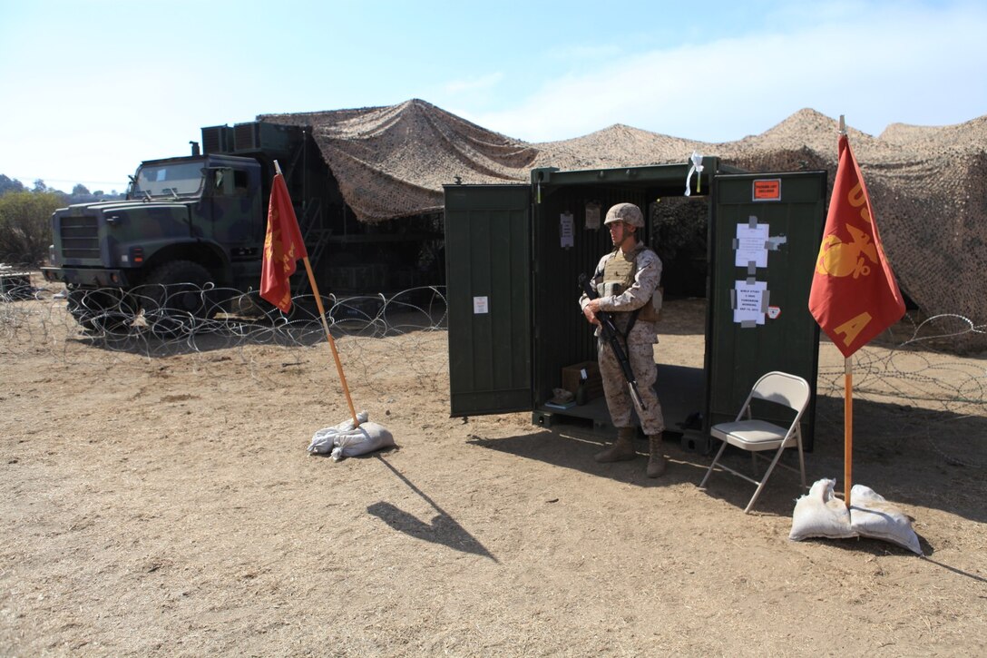 Lance Cpl. Domenic Redd, field wireman, 9th Communication Battalion, guards the main communication hub during a month long field exercise. 9th Com Bn., simulated a 1st Marine Expeditionary Brigade deployment situation.